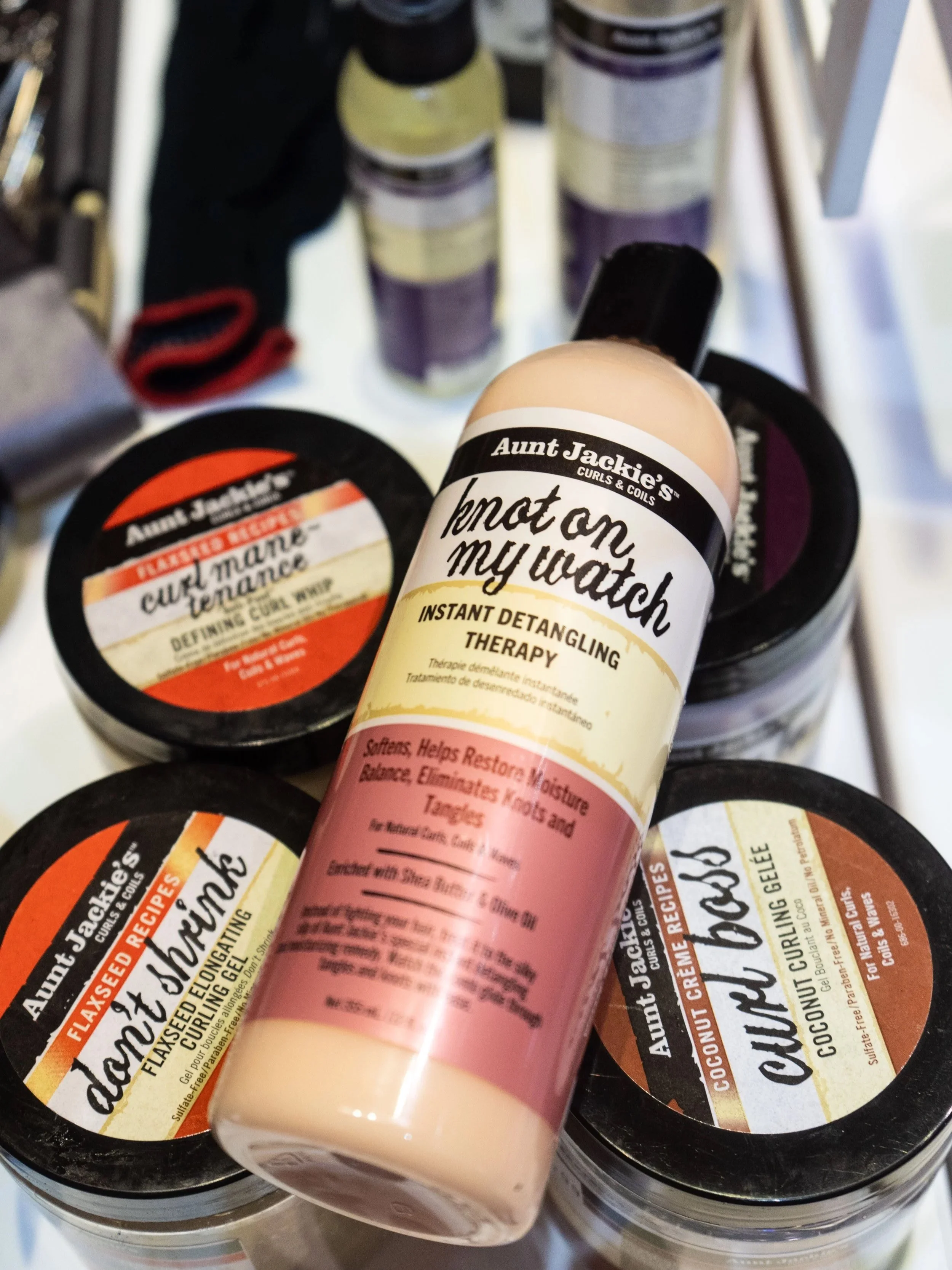 Collection of Aunt Jackie's hair care products including deep conditioning masks and detangling therapy spray.