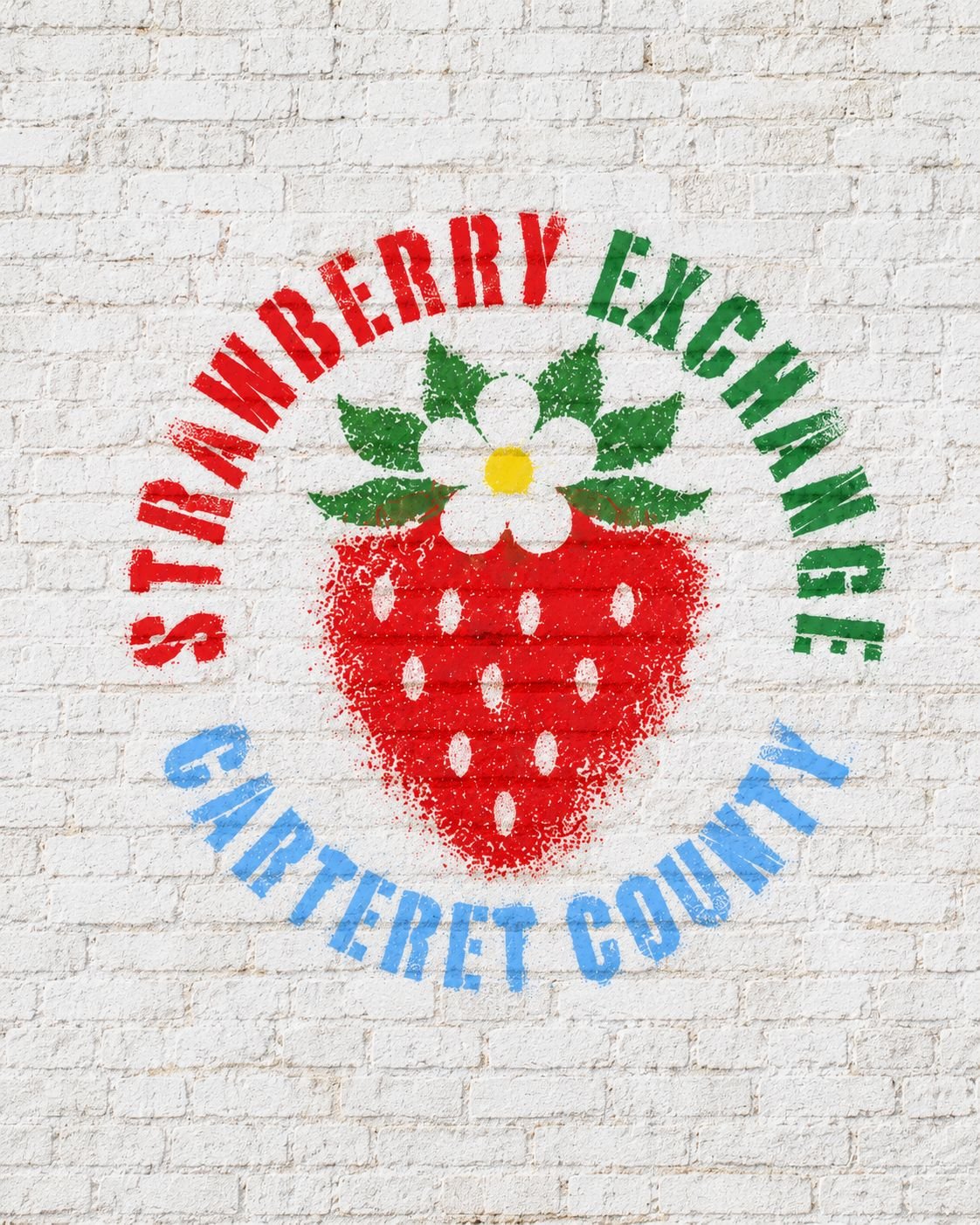 Stencil of a bright red strawberry with white flower and green leaves, surrounded by “Strawberry Engine” and “Canteret County” text on brick.