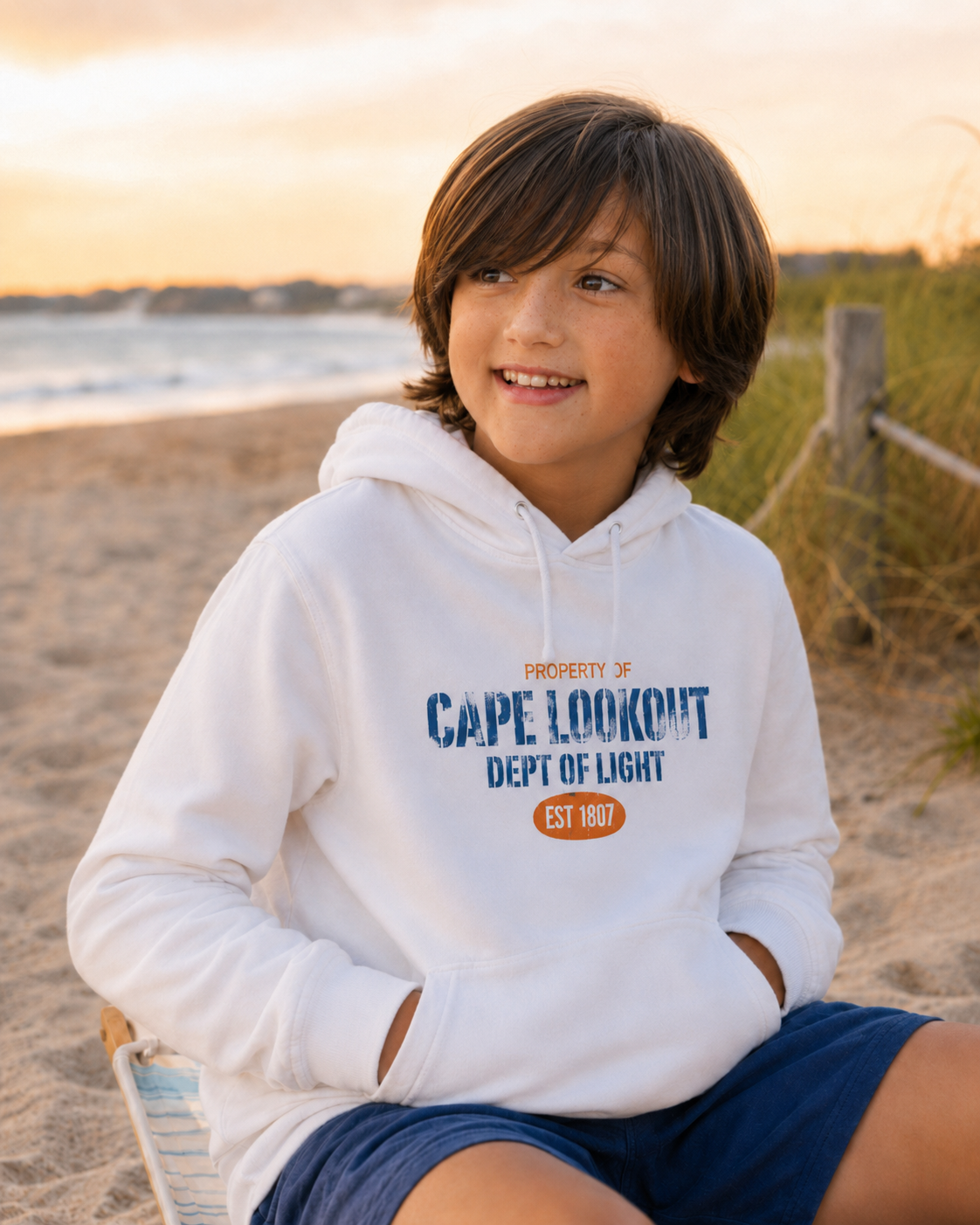 young boy in crystal coast wearing Cape Lookout Hoodie