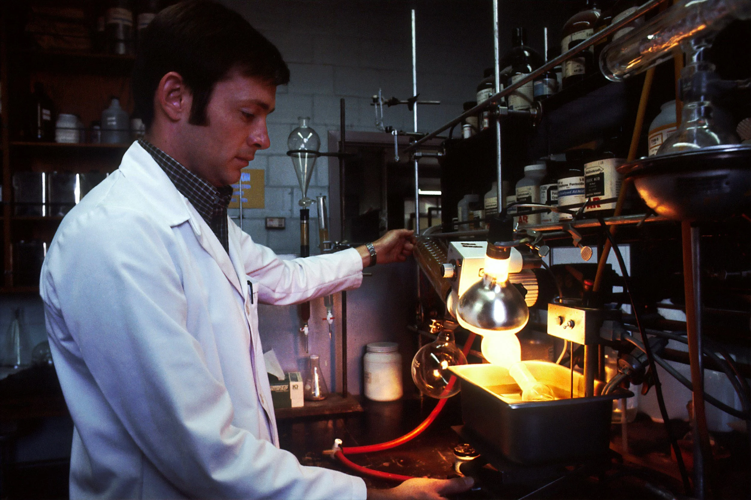 Scientist in a white lab coat operating equipment in a chemistry laboratory