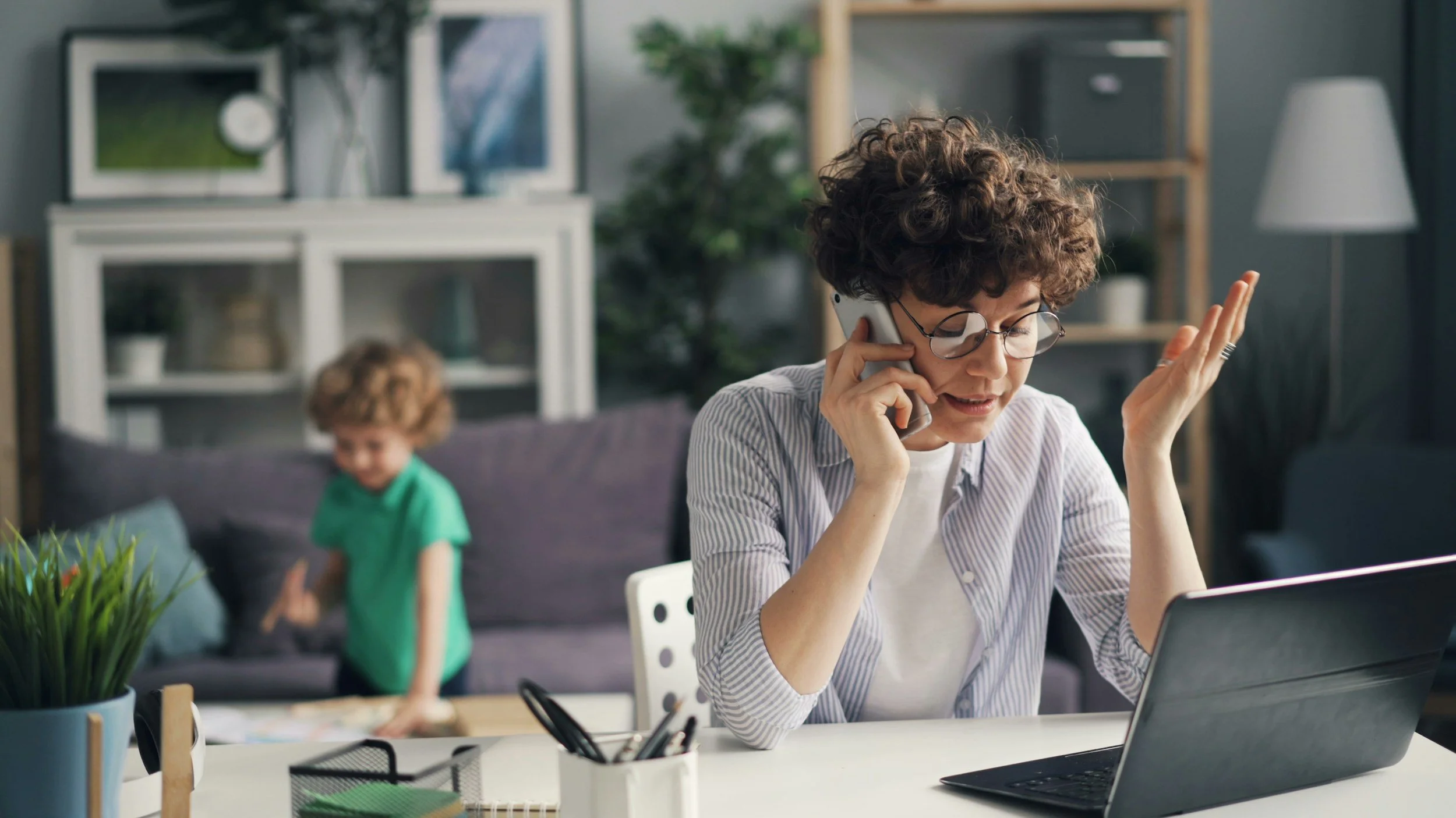 Mom working from home, frustrated with child needing help while she is in a meeting.