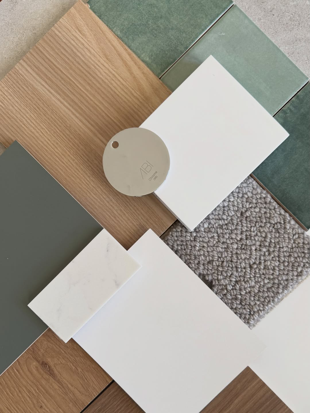 Collection of various textured and colored material samples including wood, stone, ceramic, marble, and fabric, arranged on a flat surface.
