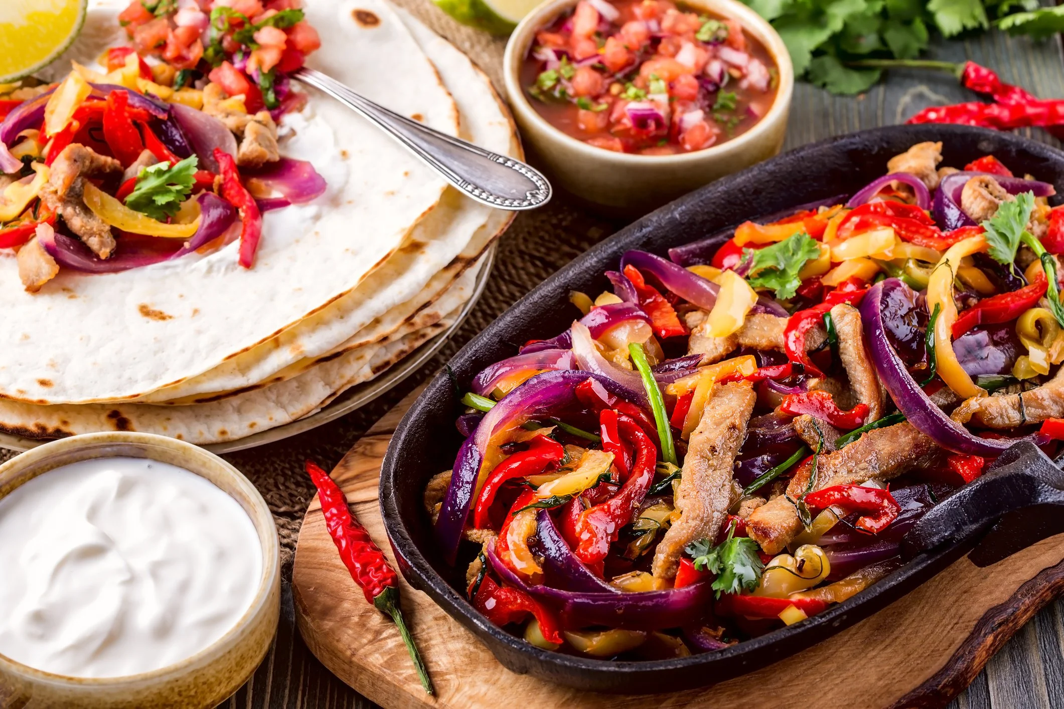 Healthy nutrition and wellness coaching for midlife women: A colorful Mexican meal served in a cast iron skillet with fresh stir-fried vegetables, vibrant salsa, and warm tortillas, representing nourishing retreat catering.