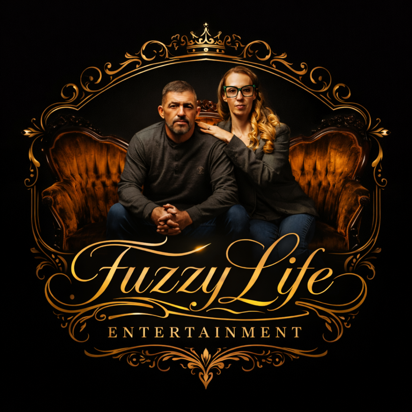 A man and woman sitting on a vintage brown velvet sofa against a black background, with ornate gold frame around them. The woman has long, curled blonde hair, glasses, and is wearing a dark blazer, while the man has short hair, a beard, and is wearing a dark shirt. The text "Fuzzy Life" is written in gold cursive font, with "Entertainment" below in capital letters.