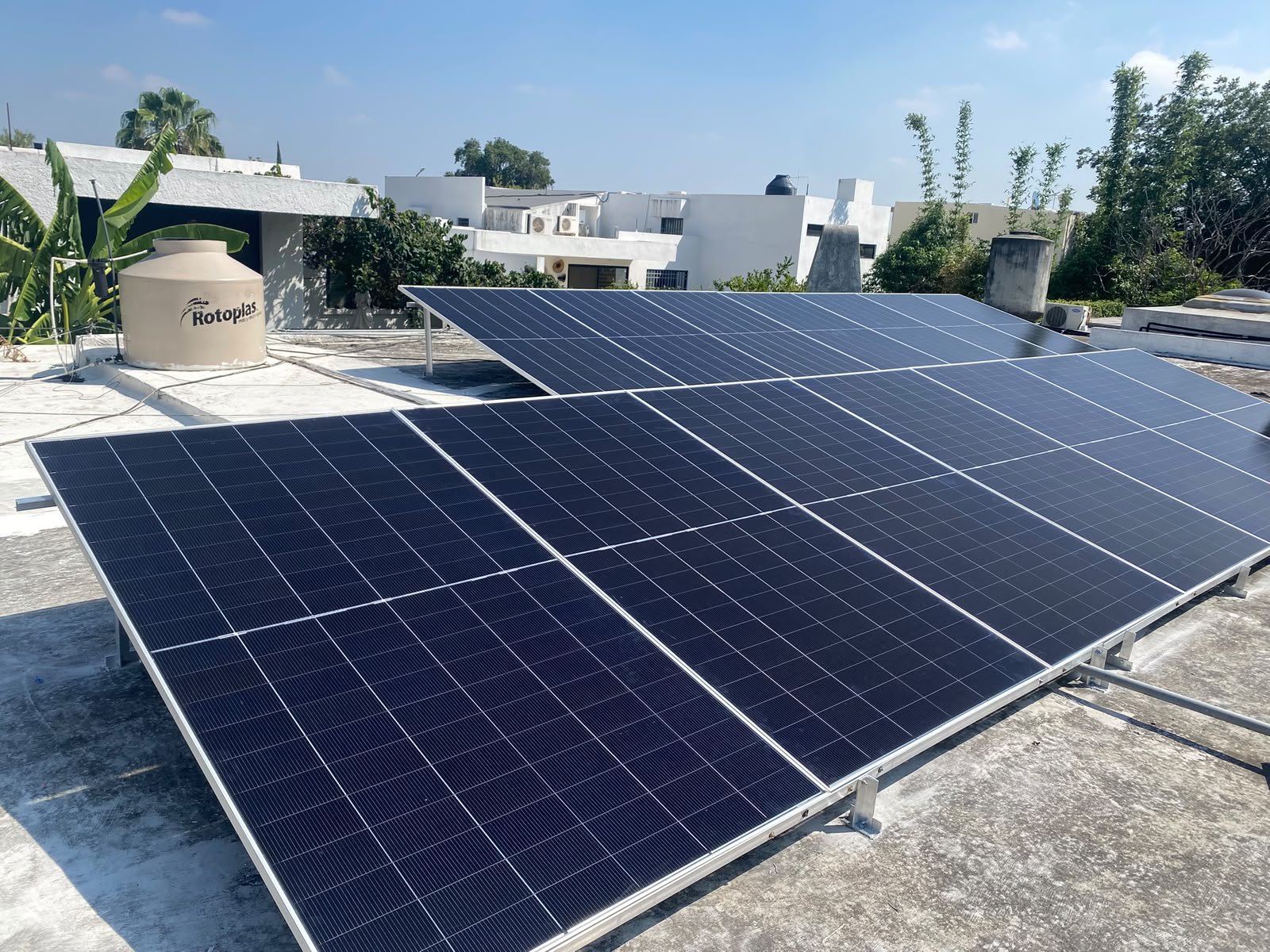 Paneles solares instalados en un techo de una casa en un día soleado.