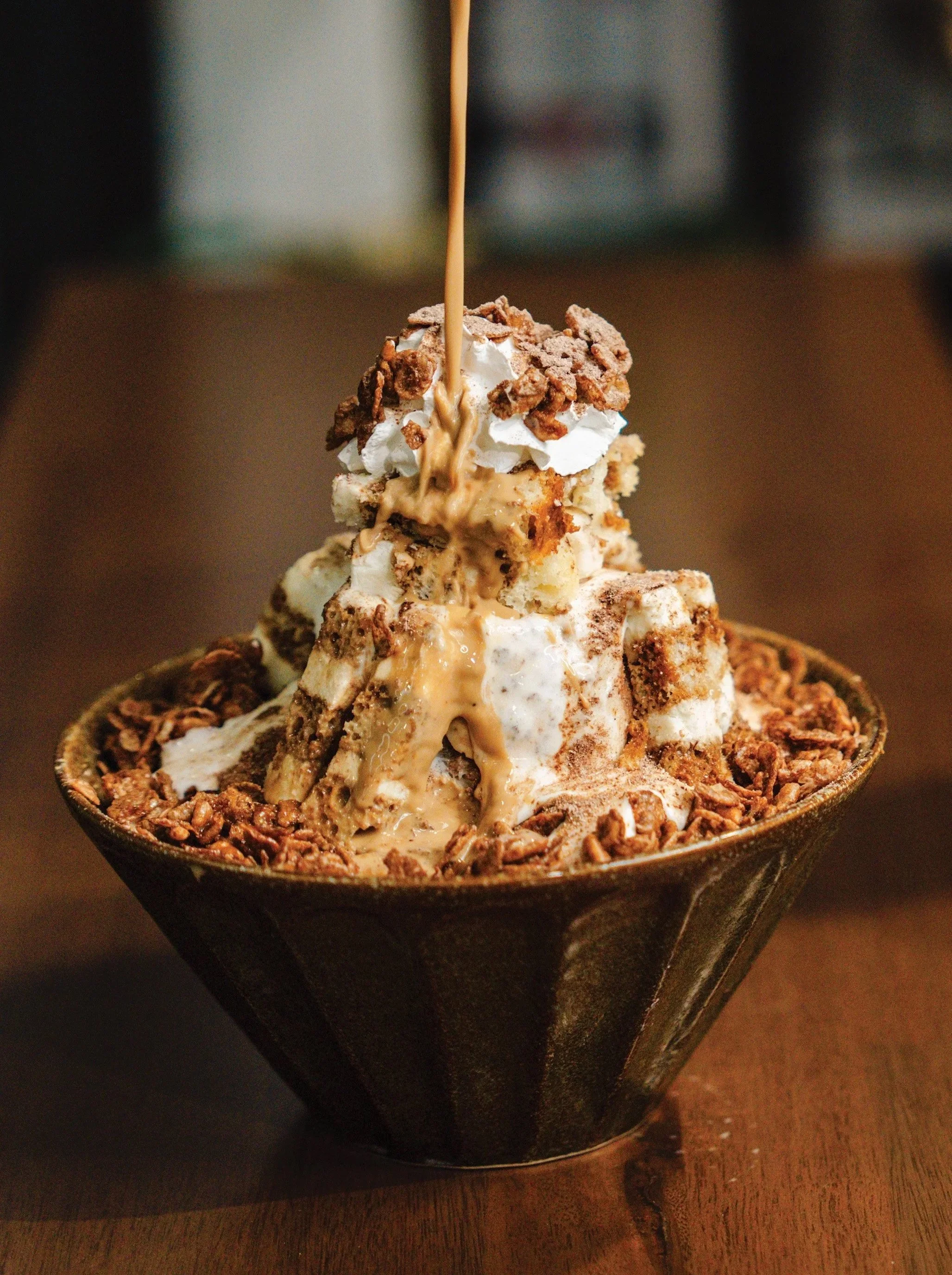 Tiramisu Bingsu shaved ice dessert with espresso, mascarpone, and cocoa at Bingsu Tea. Korean shaved milky ice served with icecream in the middle and a slice of tiramisu on top.