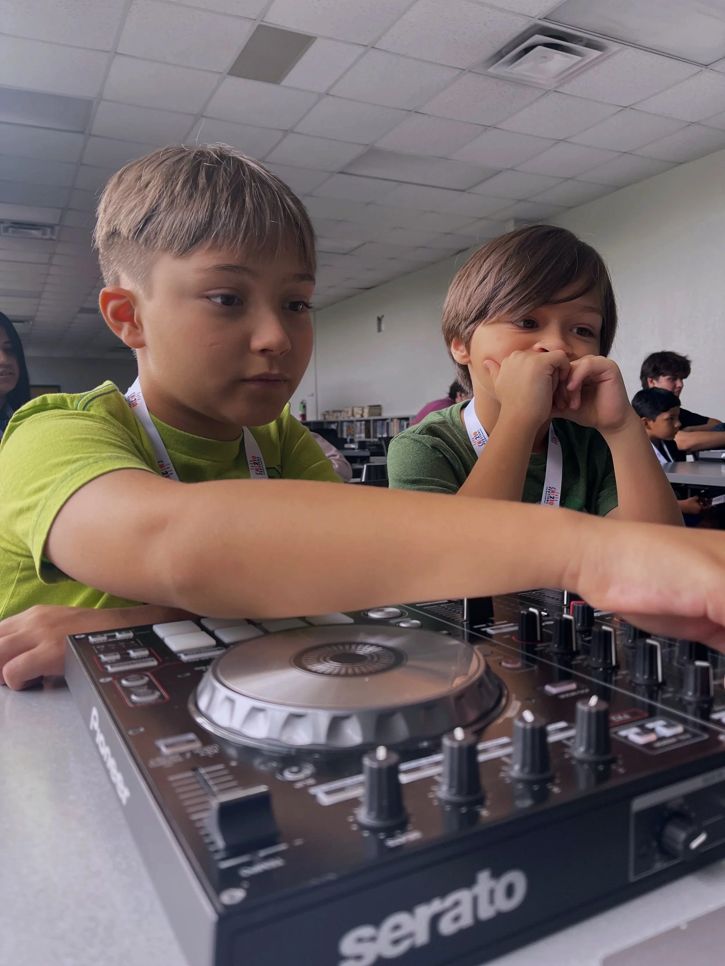 Students learning together with DJ equipment during an AM Project class, building collaboration and hands-on music skills.