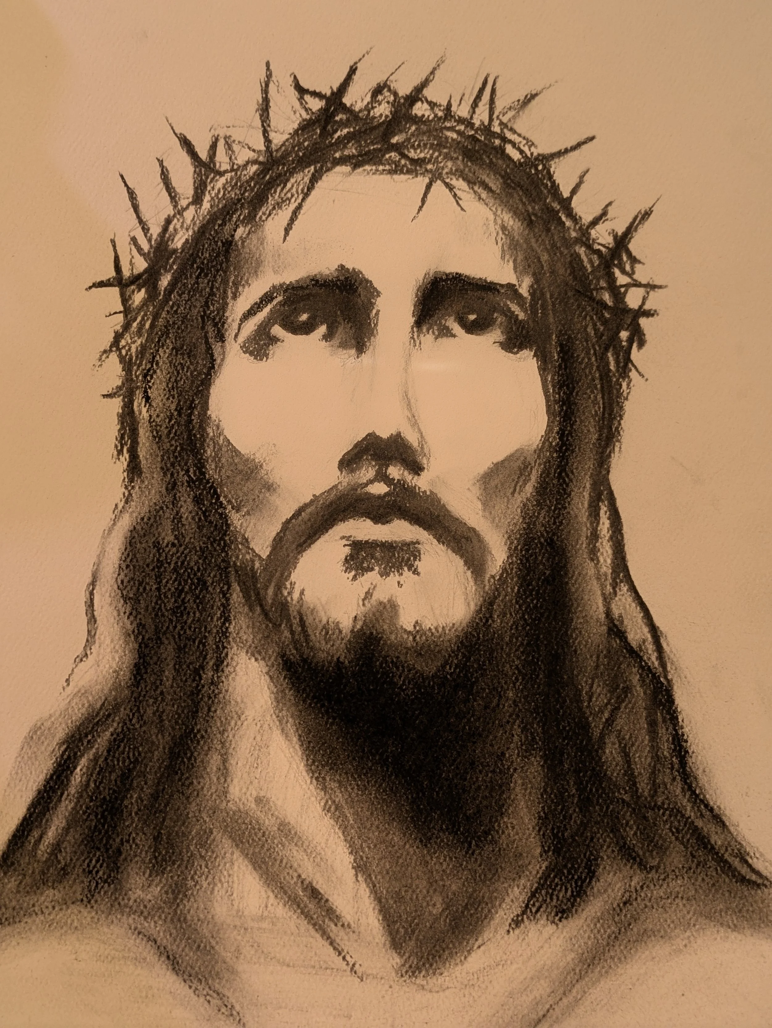 A monochrome drawing of Jesus Christ with a crown of thorns on his head.