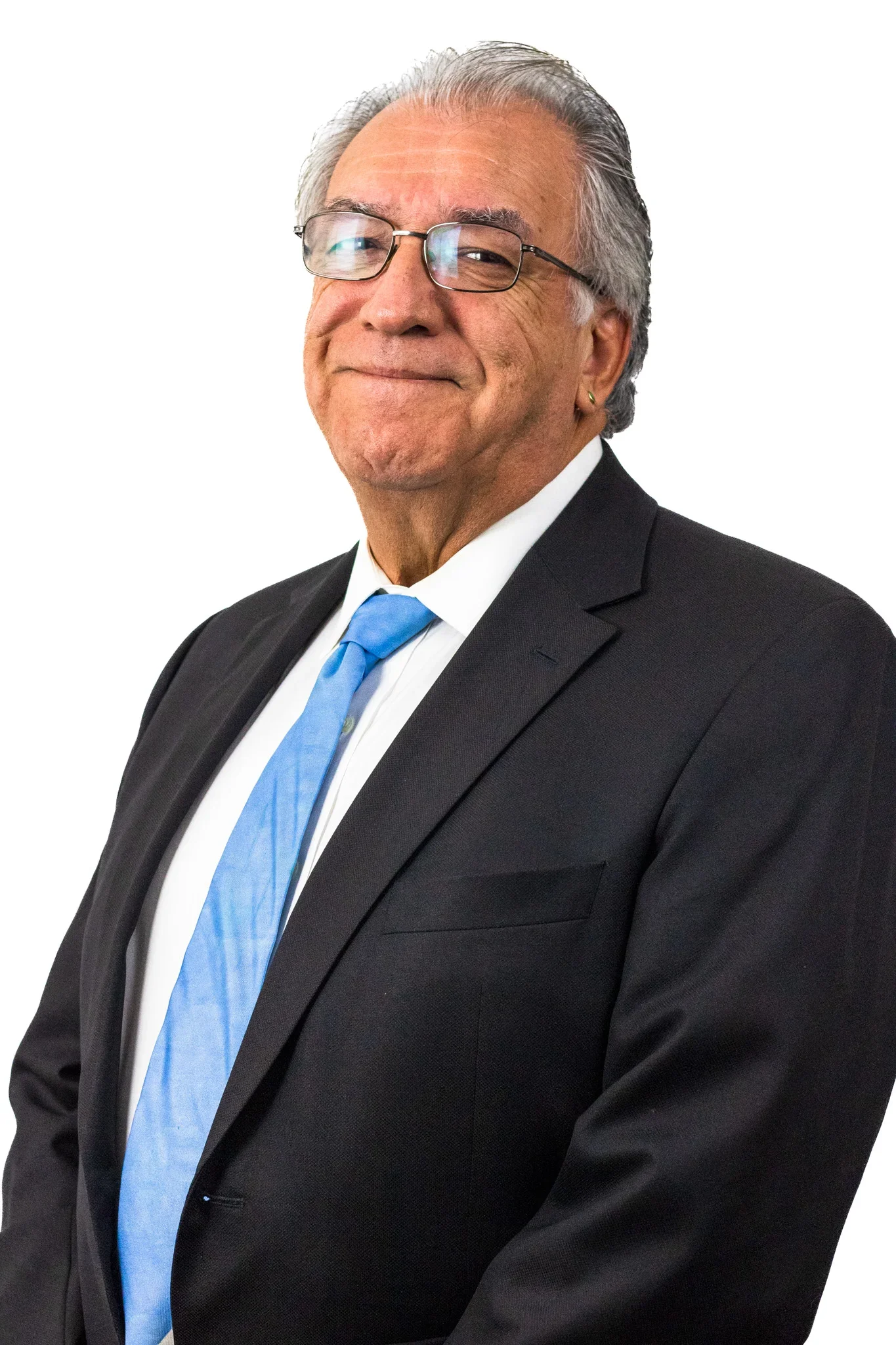 A middle-aged man with gray hair and glasses wearing a black suit, white shirt, and blue tie, smiling against a plain white background.