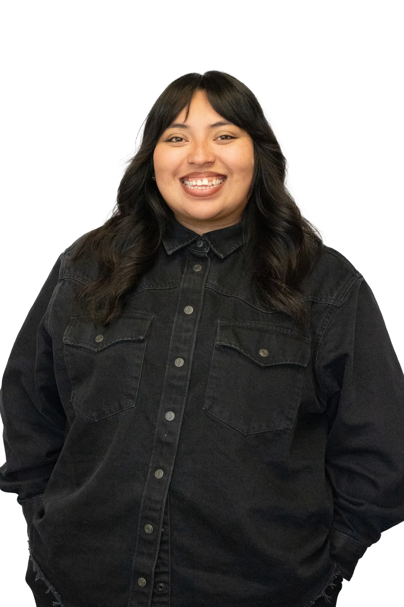 A woman smiling, wearing a black denim jacket against a plain white background.