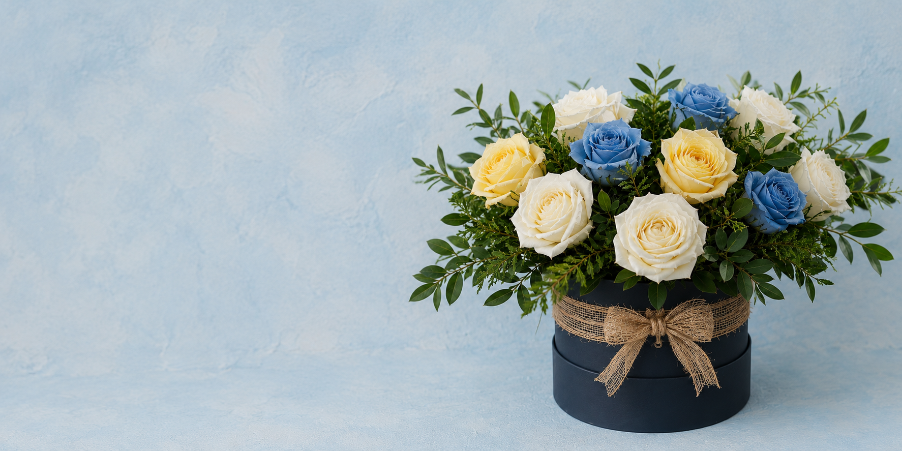 Ramo de flores de rosas blancas y azules en una caja con lazo de encaje.
