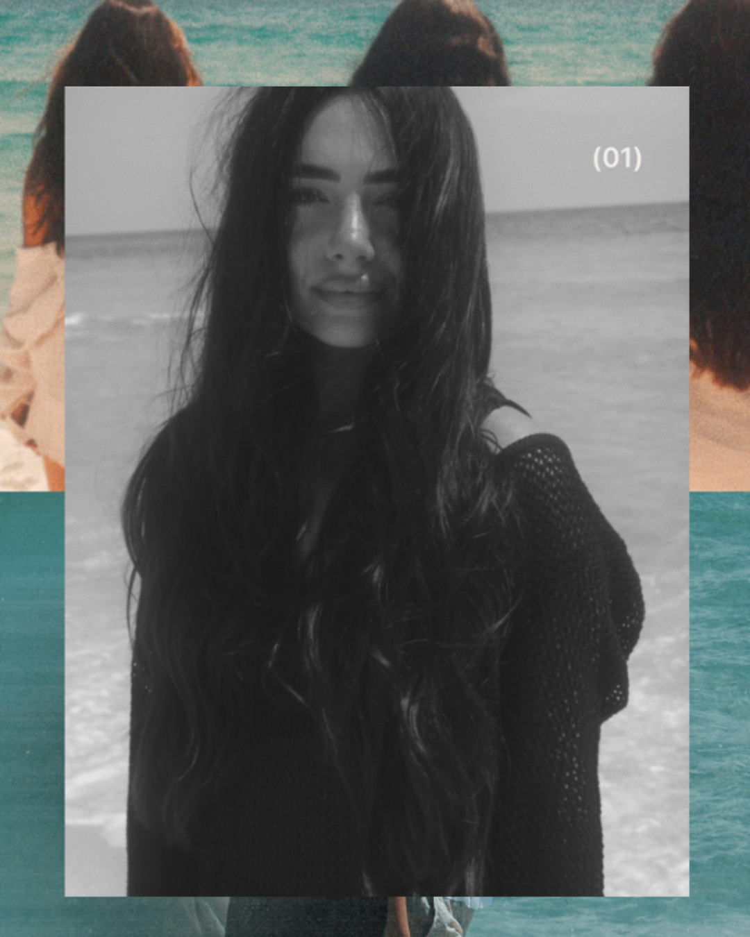 Black and white photo of a smiling woman with long, wavy hair on a beach with ocean in background.