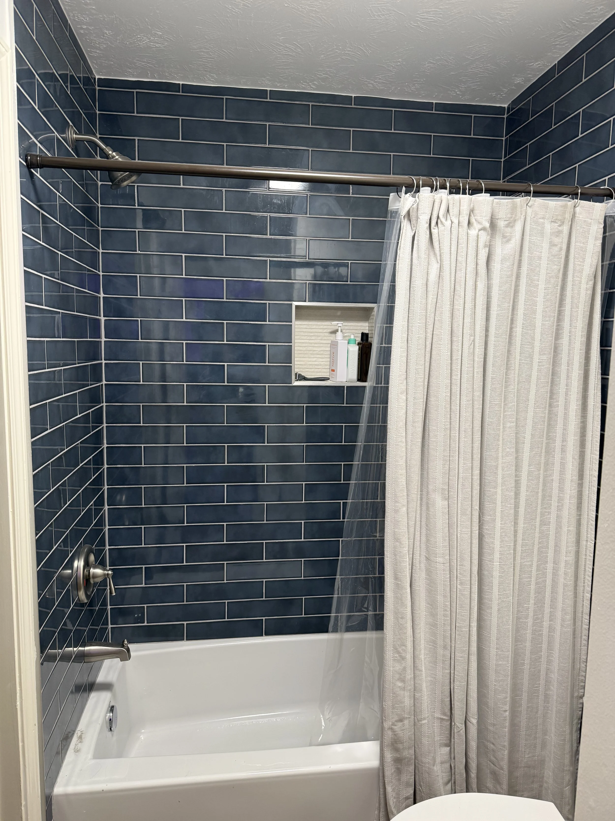 Tub surround tile installation with blue subway tile in Conroe TX by Prestige Tile Solutions