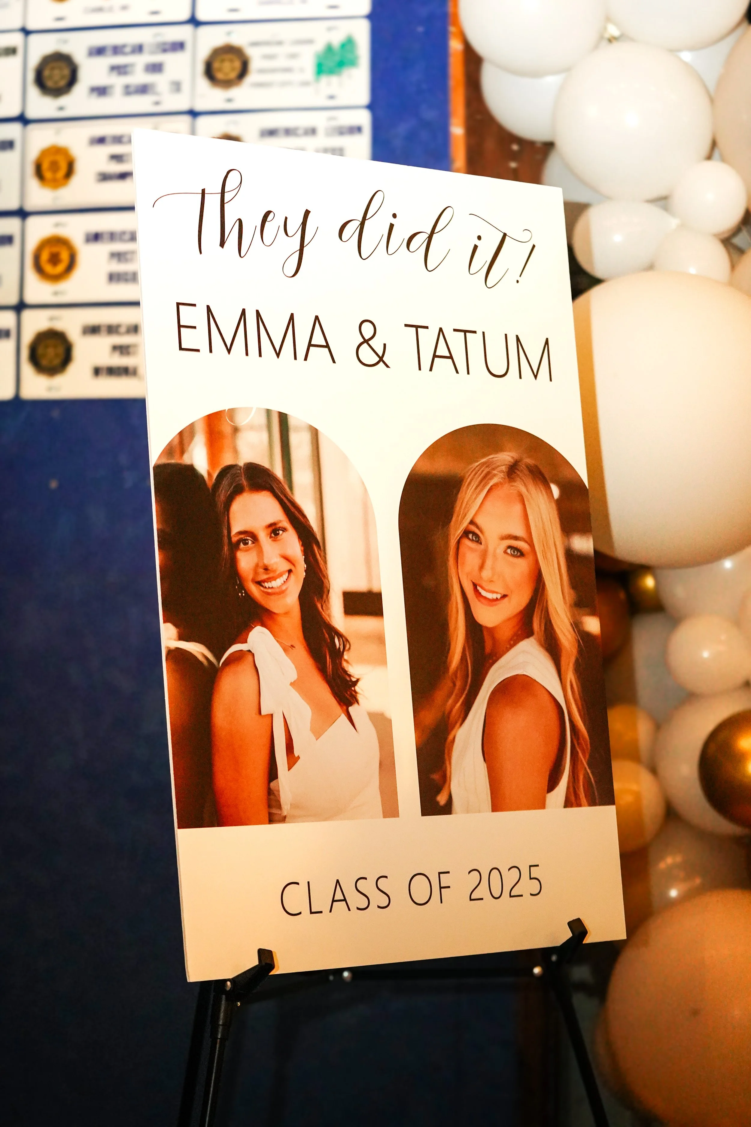 A graduation sign with photos of two women, celebrating their graduation with the message "They did it! Emma & Tatum," indicating they are part of the class of 2025.