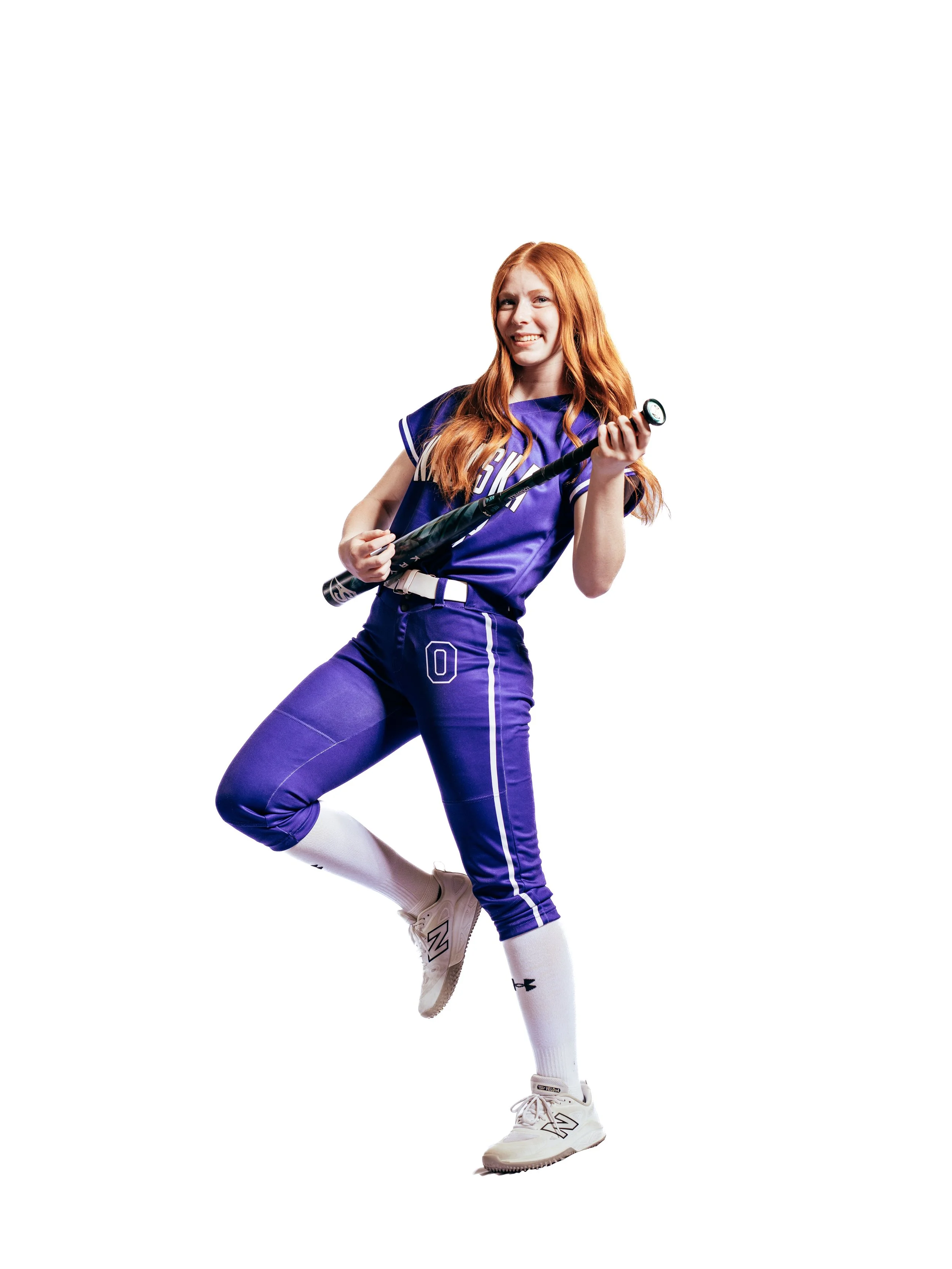 A young woman with red hair wearing a purple baseball uniform and holding a bat.
