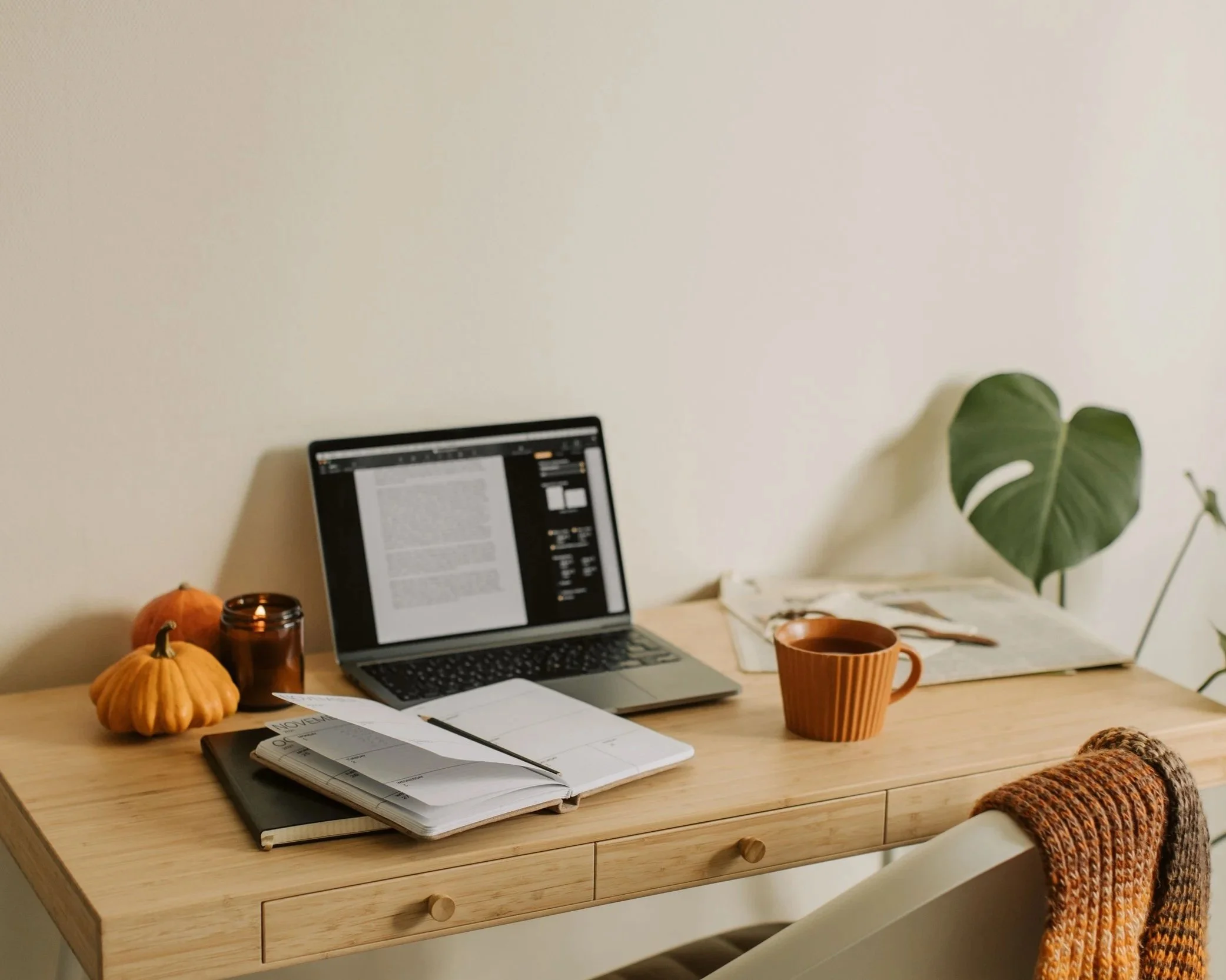 desk with a planner and notebook and laptop