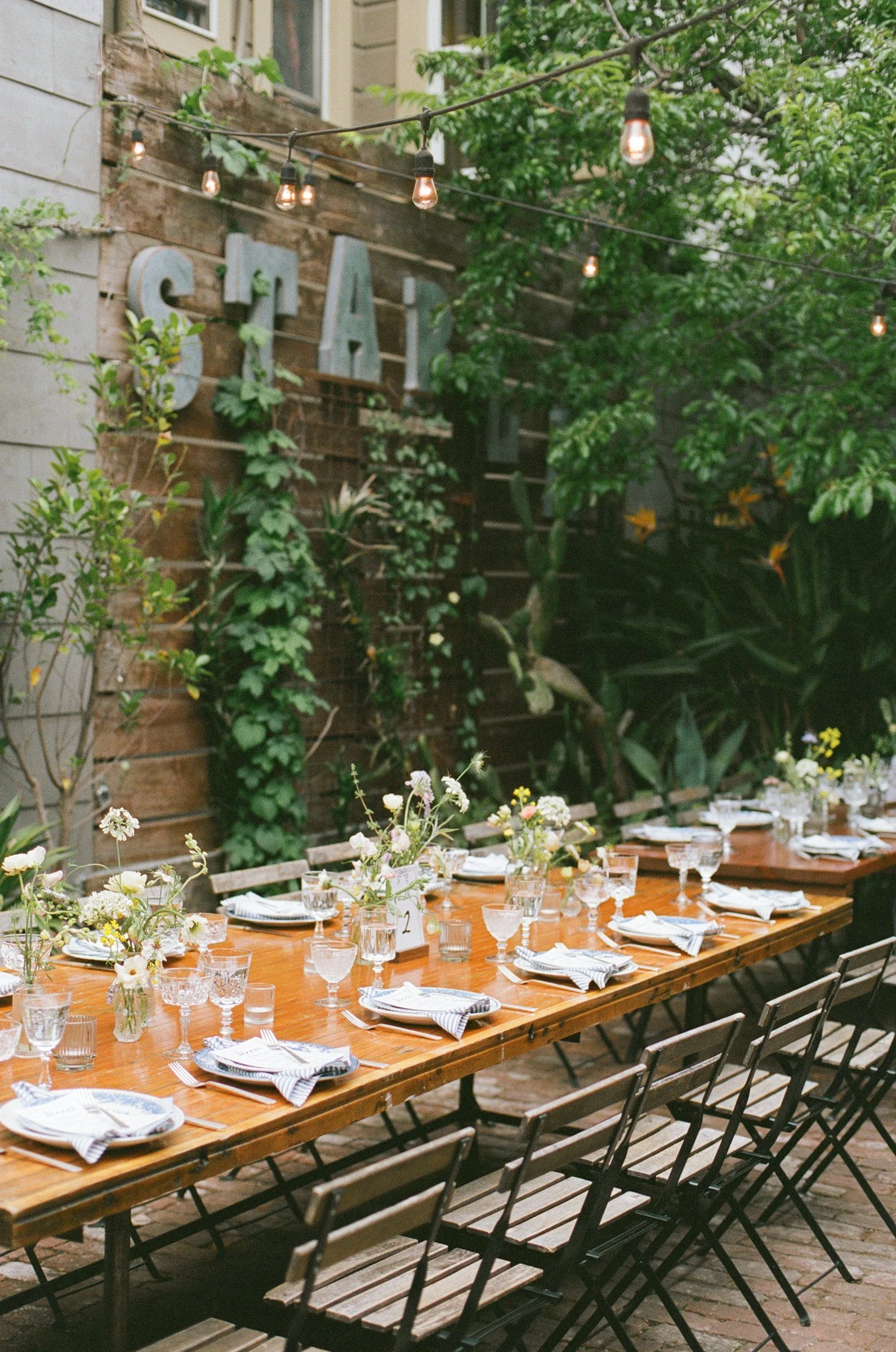 Outdoor reception long table with string lights at a San Francisco Bay Area wedding designed by Events by GS.