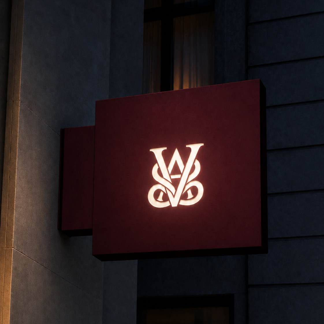 Illuminated sign with a stylized logo on a dark building exterior.
