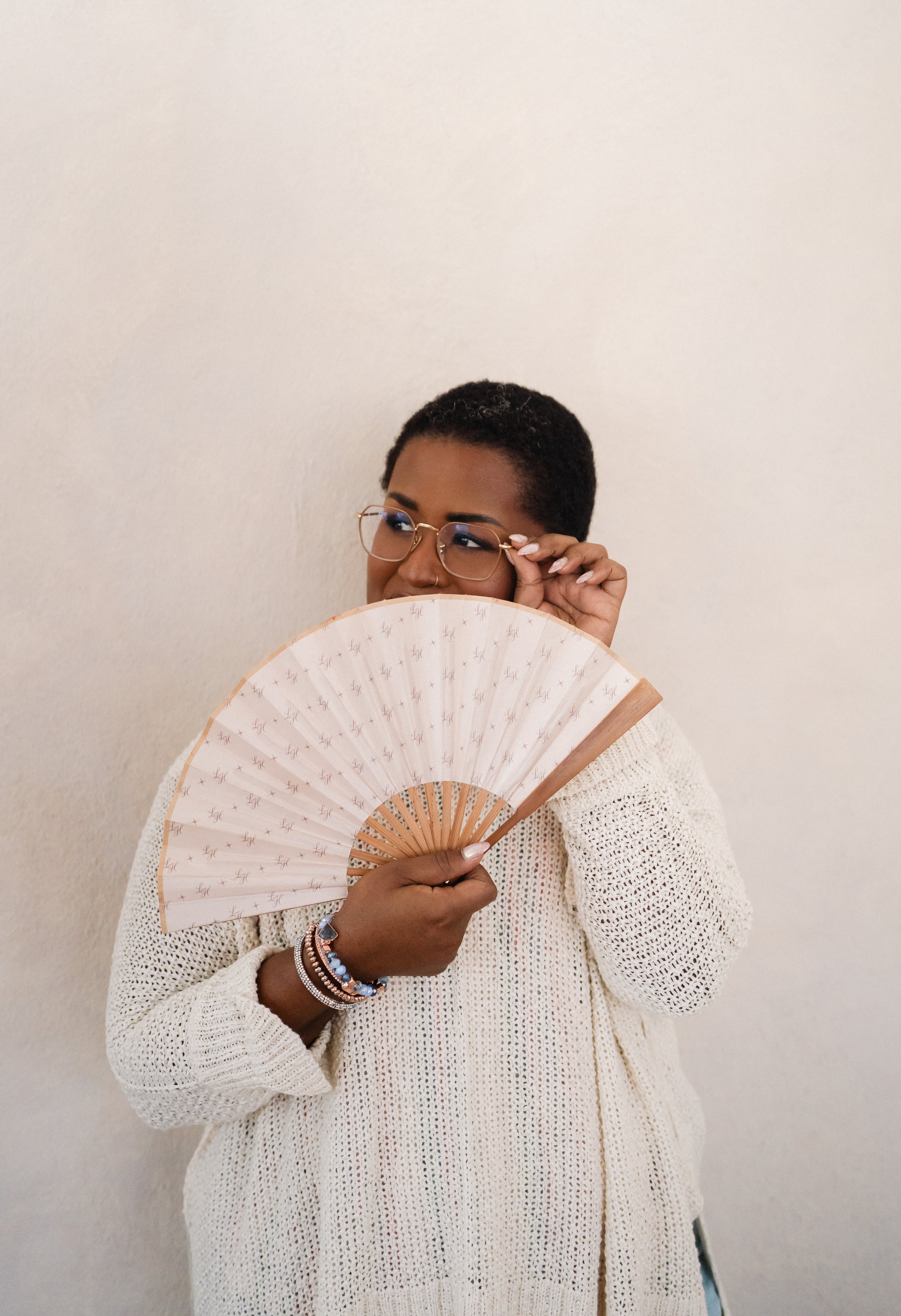 Jazmin Riordan peeking over a decorative fan