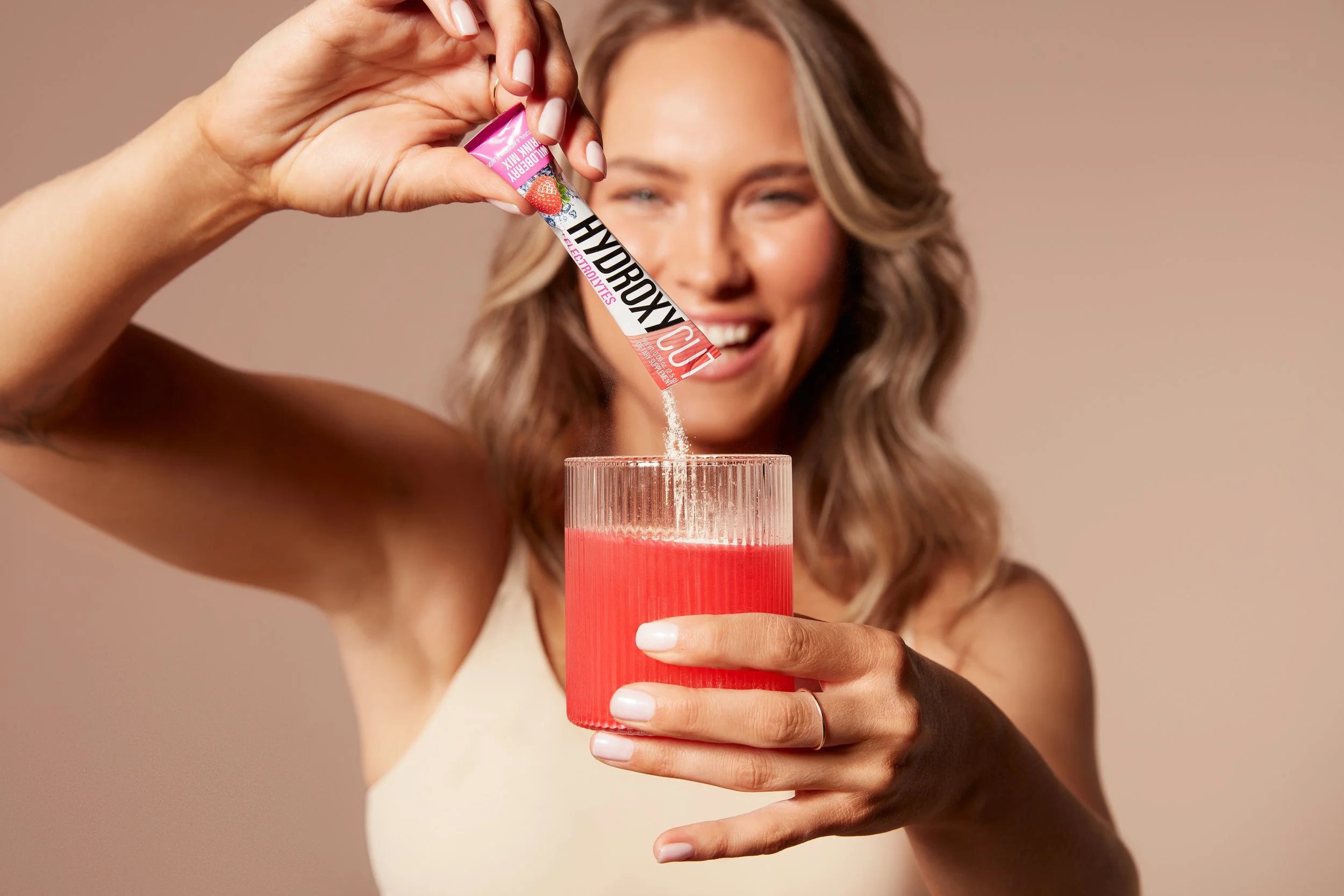 Woman Pouring Hydroxycut Drink Mix