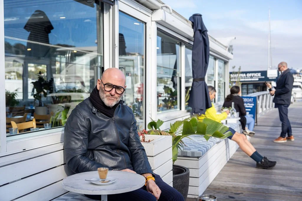 Alessandro Pavoni is sitting outside on the jetty of Chiosco by Ormeggio in Mosman.