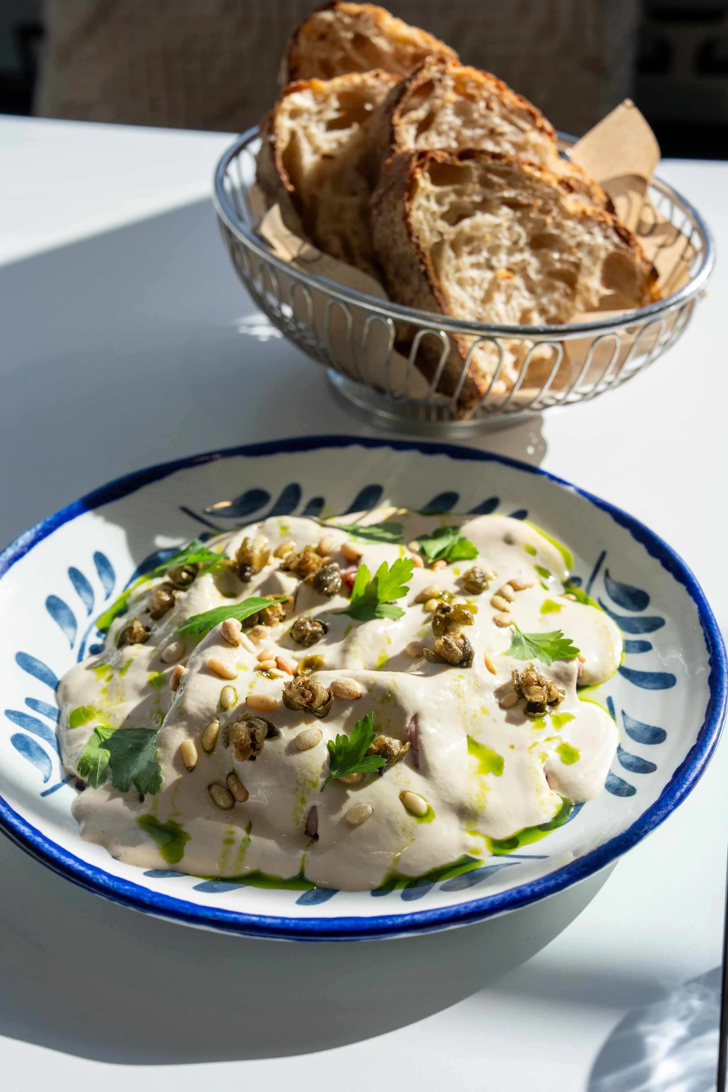 Vitello Tonnato with a basket of fresh crusty bread, a signature dish at Chiosco by Ormeggio in Mosman