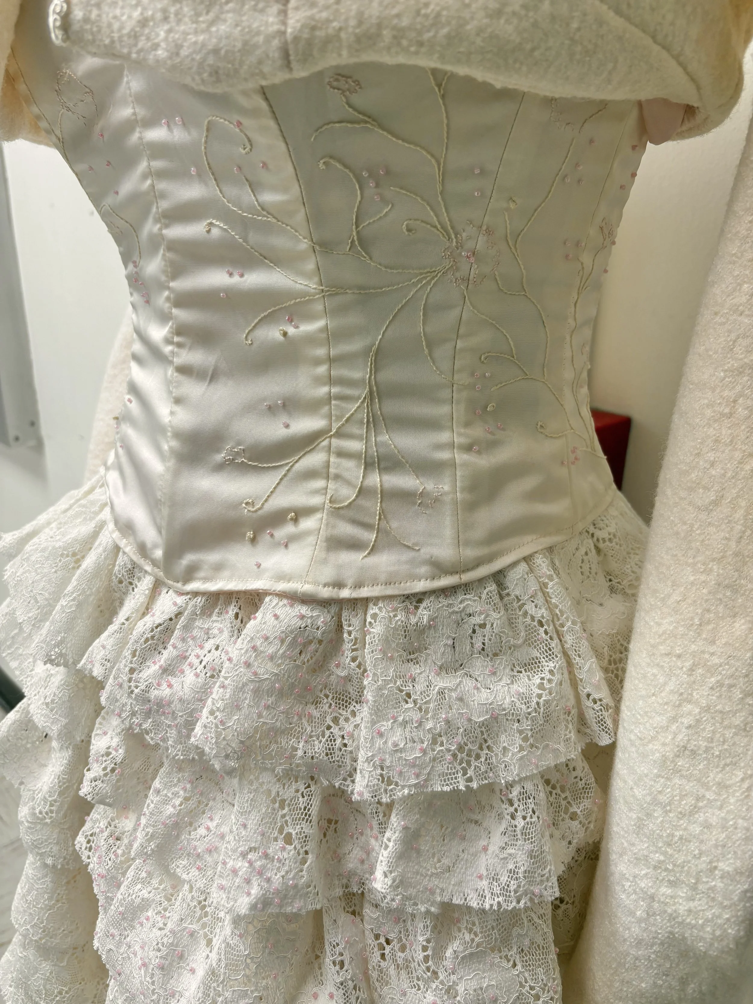 A closeup of the embroidered corset and beaded lace