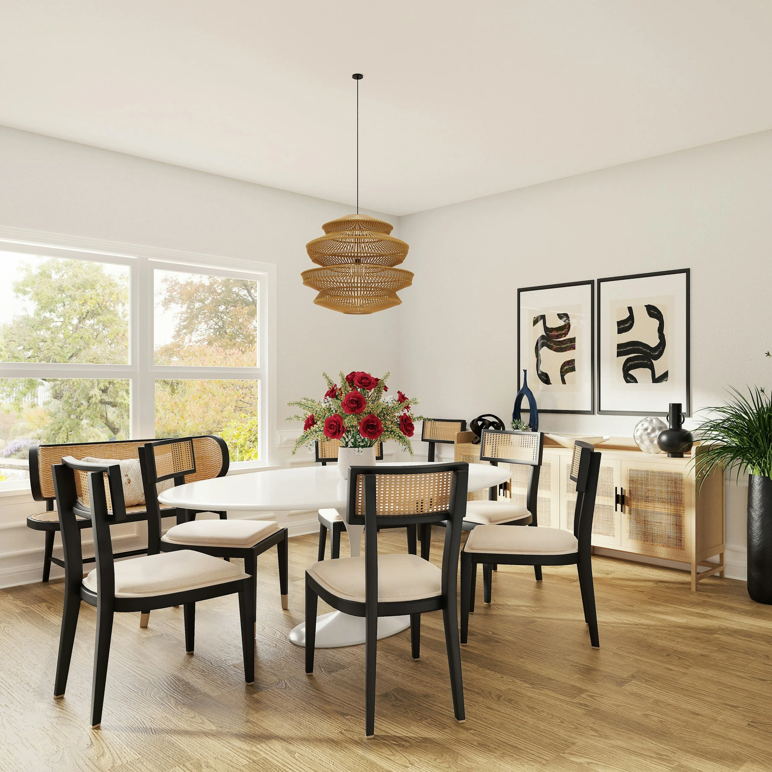 A dining room with large windows, a white round dining table, black and cane chairs, a vibrant bouquet of red roses on the table, and a woven pendant light hanging from the ceiling.