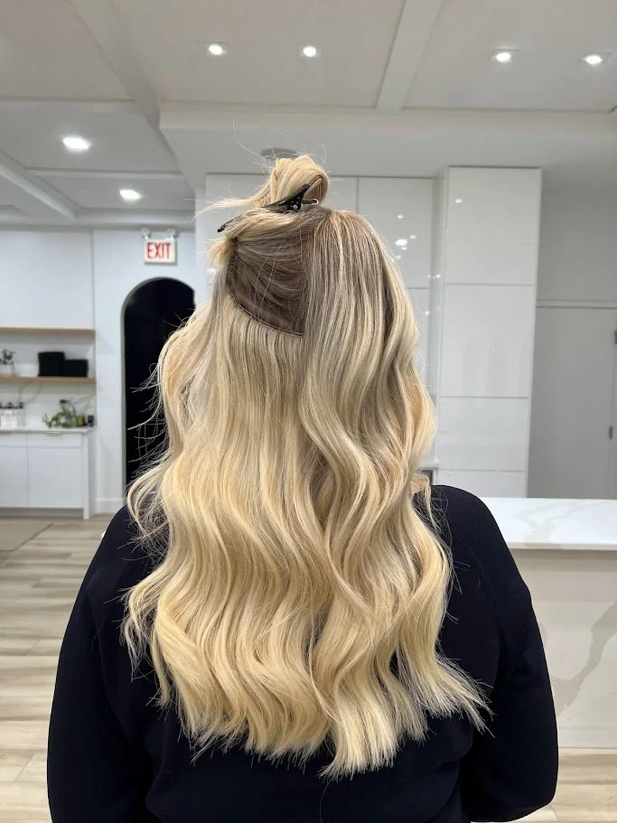 Back view of blonde hair with hand tied weft extensions in Chicago salon