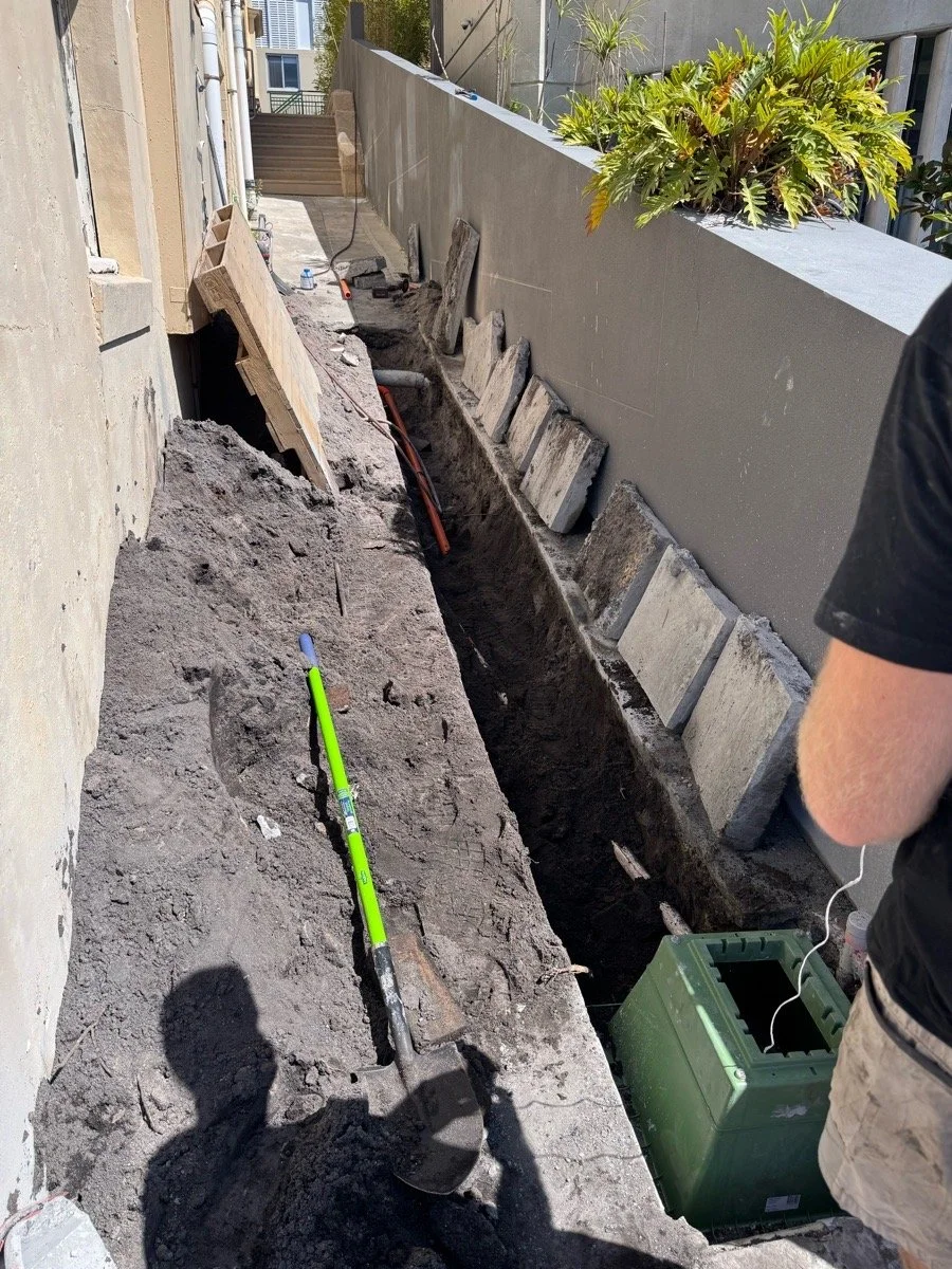 A construction site in a narrow outdoor space with excavation work ready for installation.
