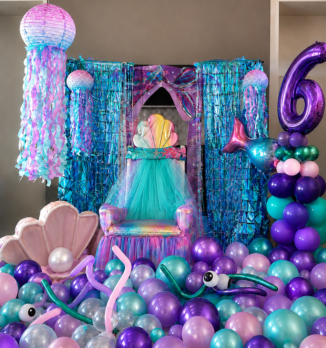 Underwater mermaid-themed party scene with a colorful throne, shell-shaped chair, sea creature balloons, and an oceanic backdrop of blue and purple decorations.