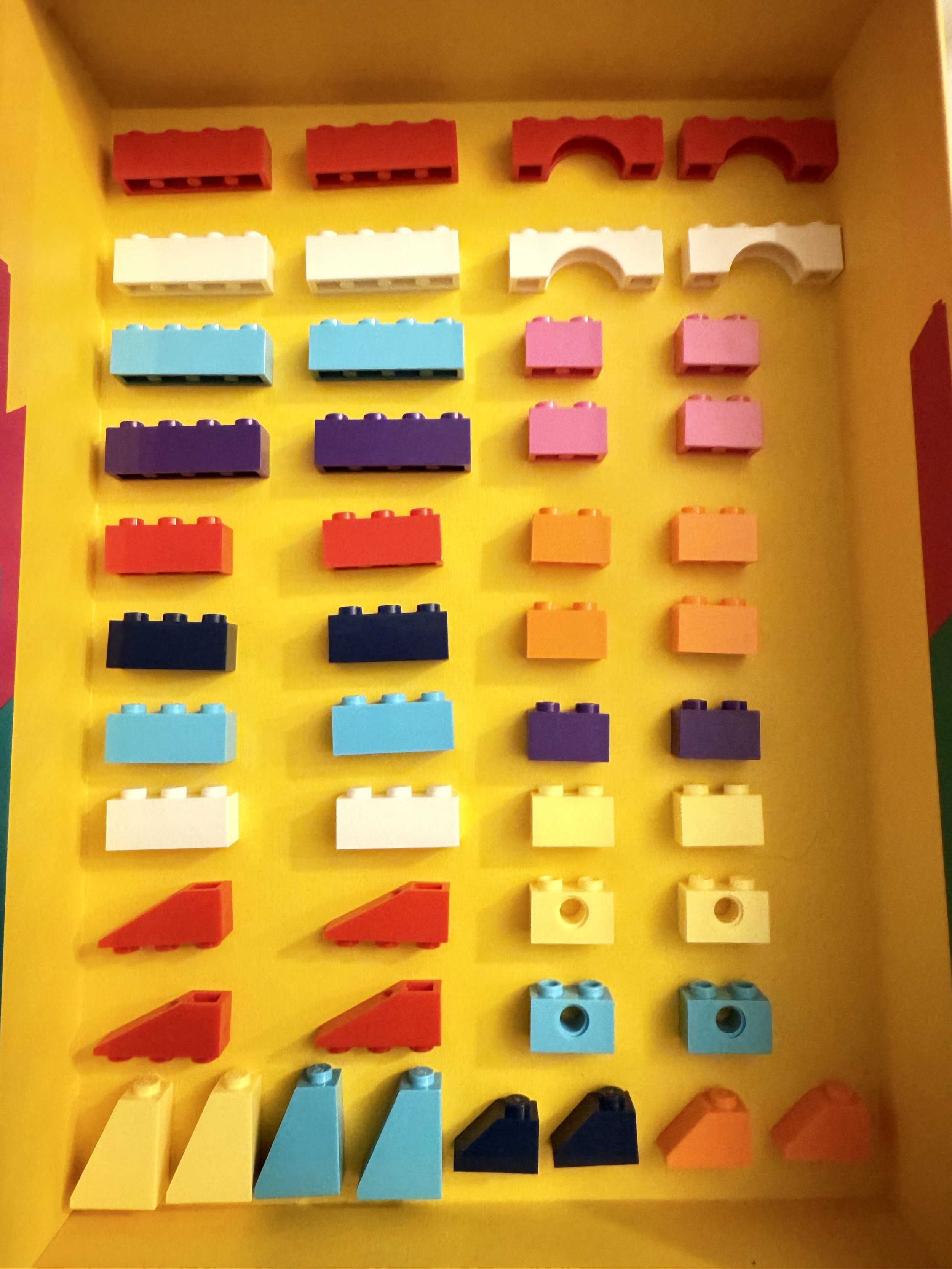Colorful building blocks organized in rows inside a yellow box.