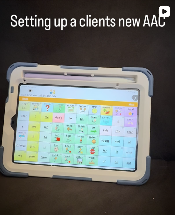 Tablet device showing an educational AAC app for clients, with various colorful buttons containing words and phrases for communication.