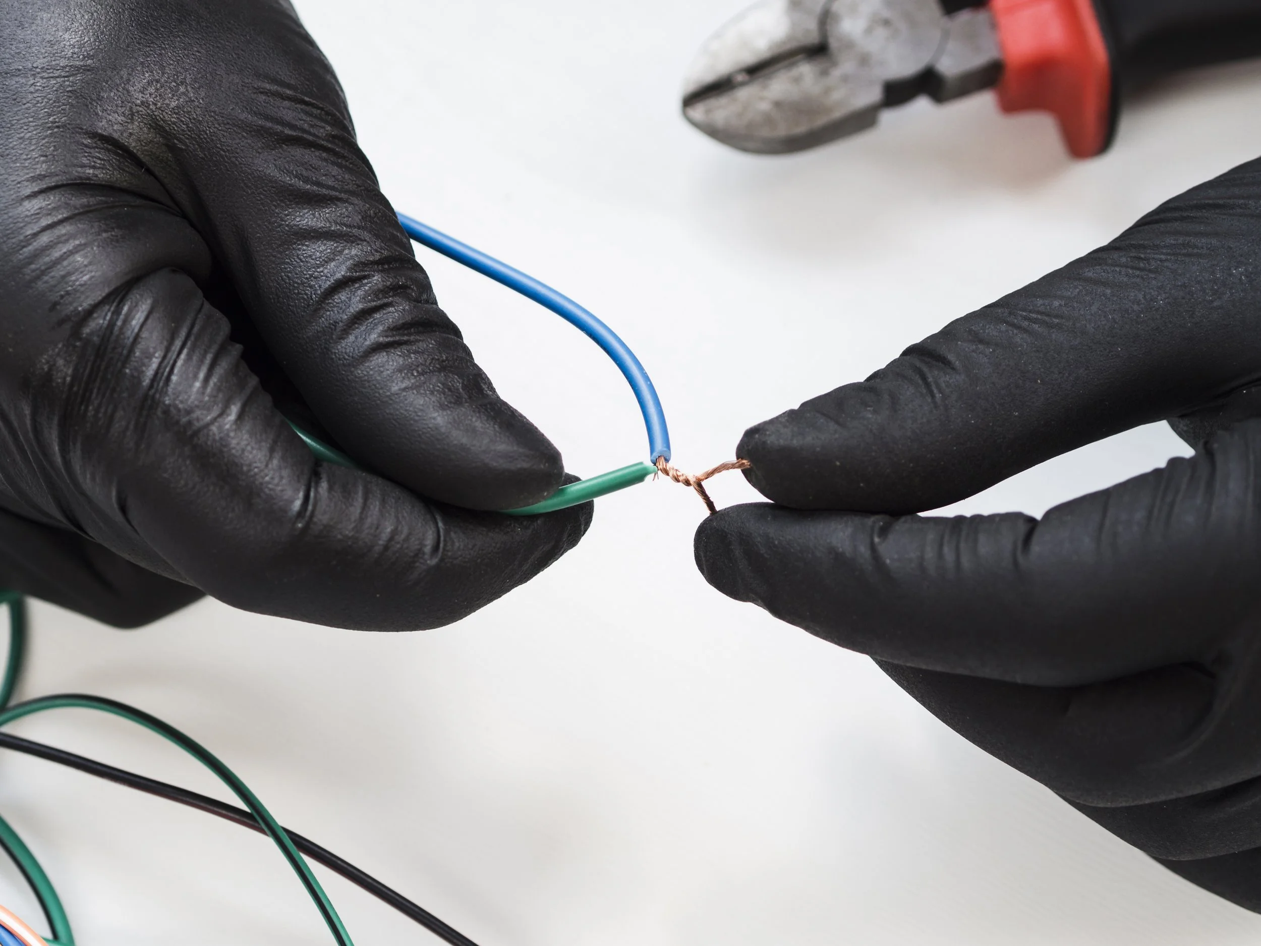 hands-with-black-gloves-connecting-wires.jpg