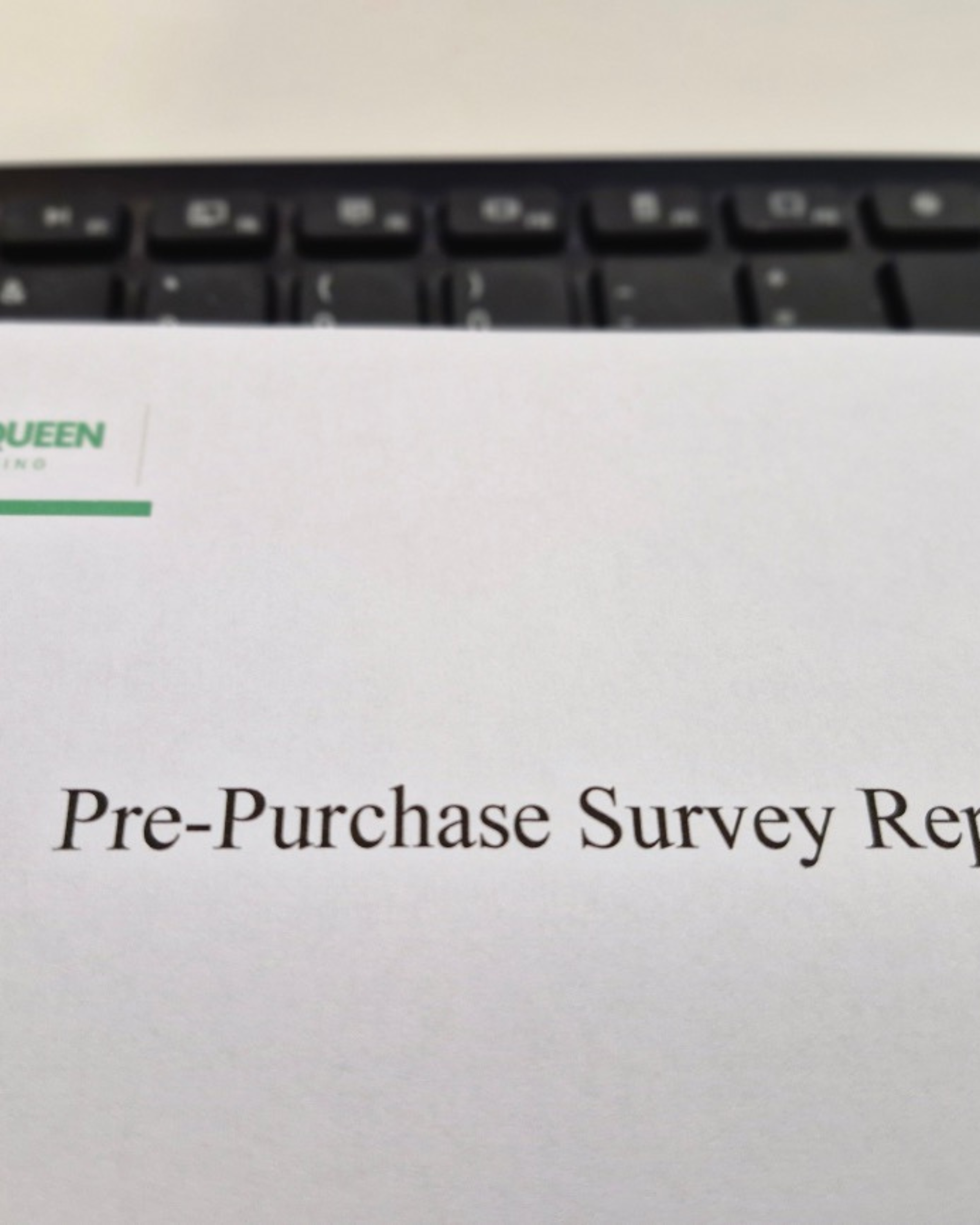 Close-up of a document with the title "Pre-Purchase Survey Re" partially visible, placed on a surface with part of a keyboard in the background.