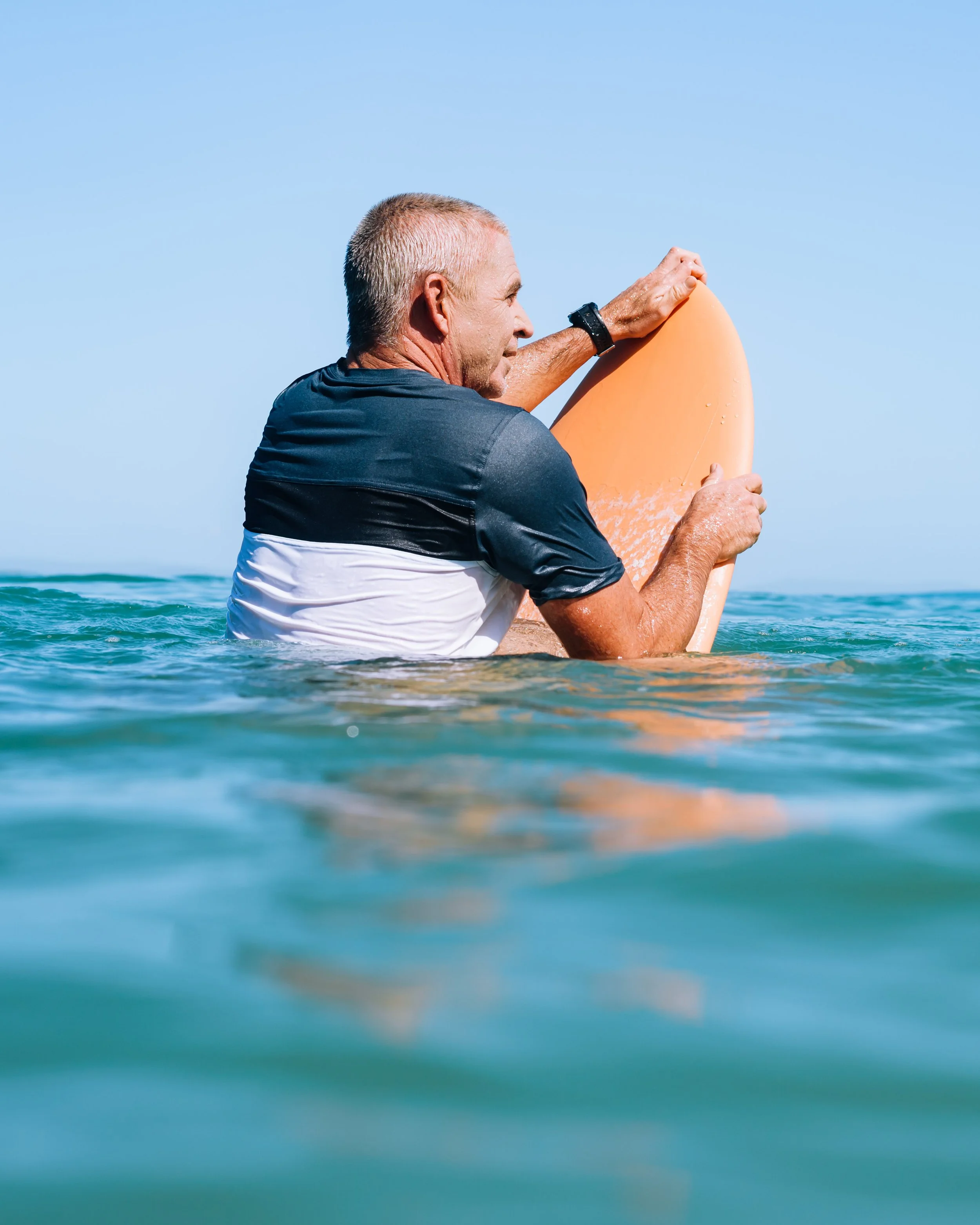 Professional surf coach Chris Prewitt on a surfboard in the water in Noosa