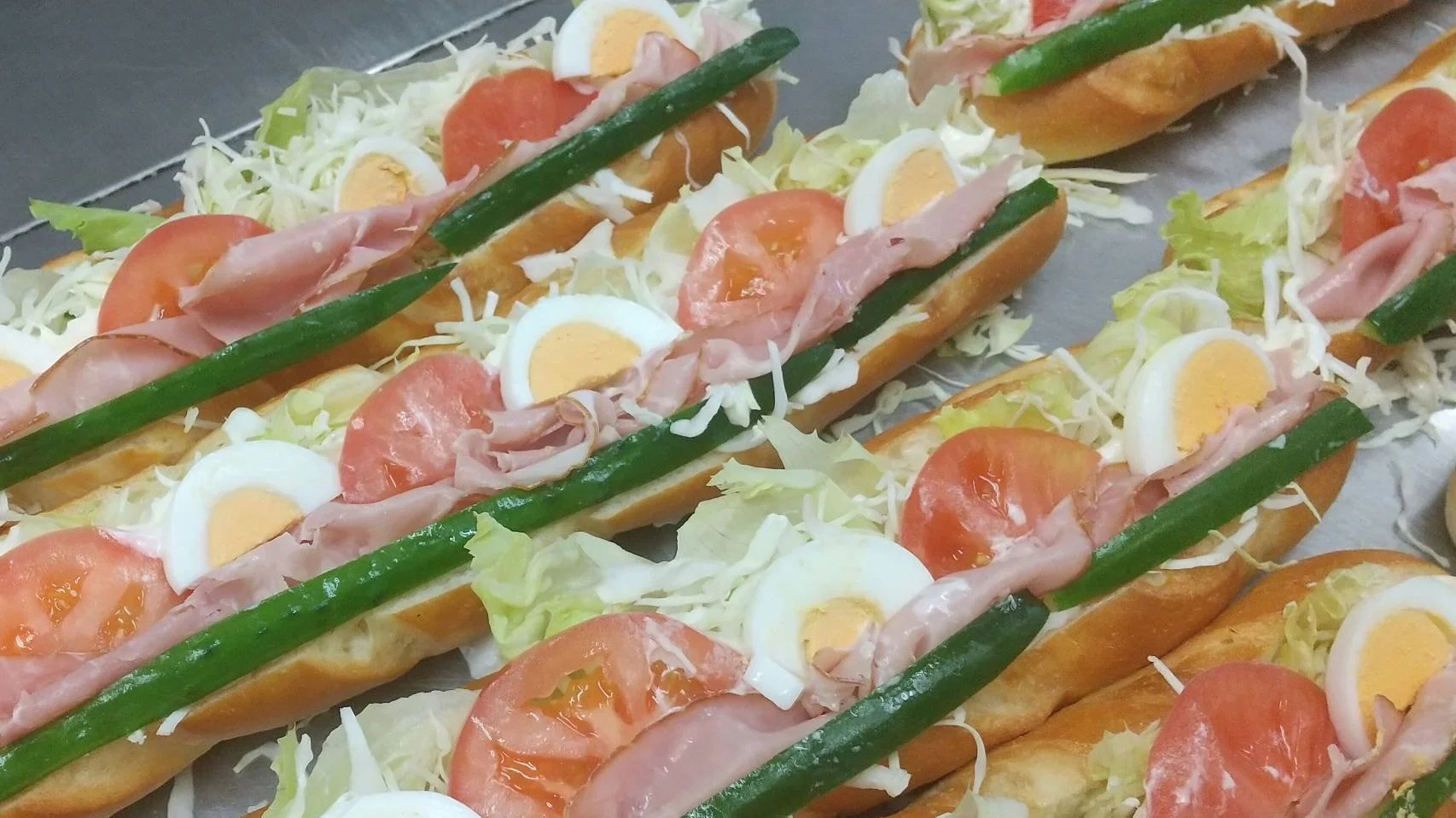 ロングサイズのオープンサンドにレタス、トマト、ゆで卵、ハム、きゅうり、千切りキャベツがトッピングされた「野菜畑」
