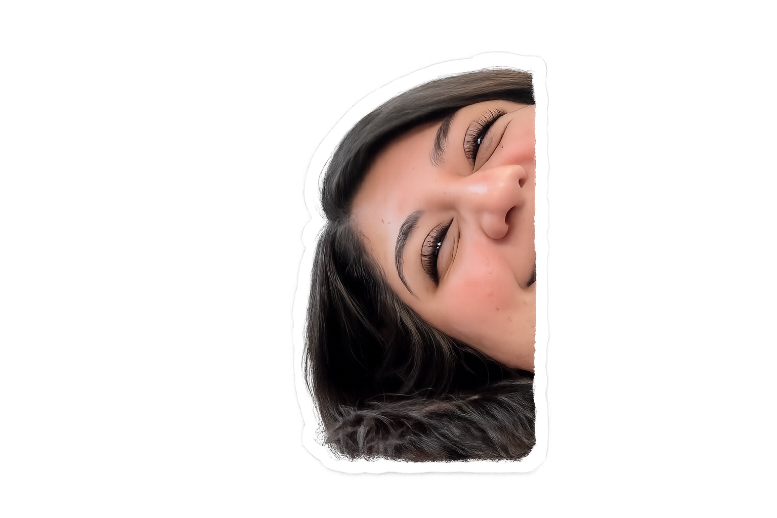 Close-up of a young woman smiling with her eyes closed, lying on her side with dark hair.
