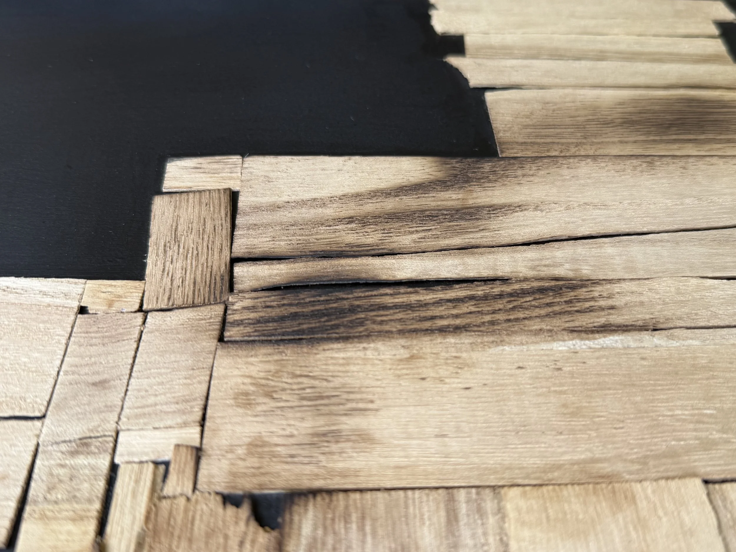 Detail of stacked compressed and scorched timber from Load Bearing by Michelle Gow.