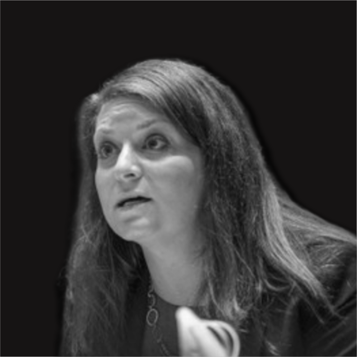 Black and white image of a woman with long hair, speaking and looking slightly to her right, against a dark background.