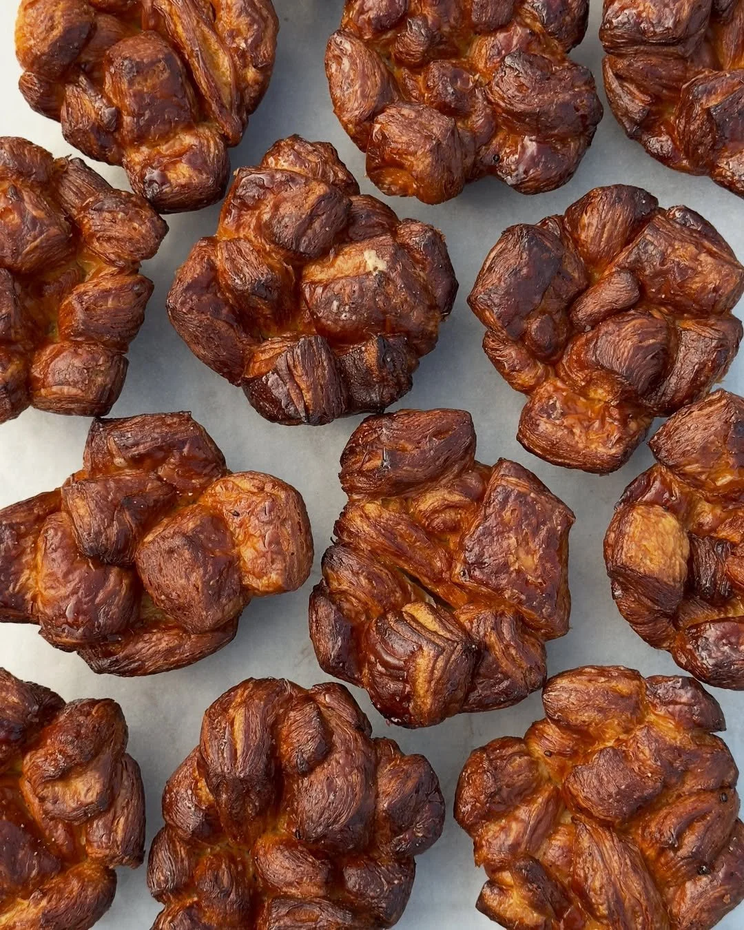 Several roasted or caramelized taffy or caramel candies with a glossy, sticky surface, arranged on a white surface.