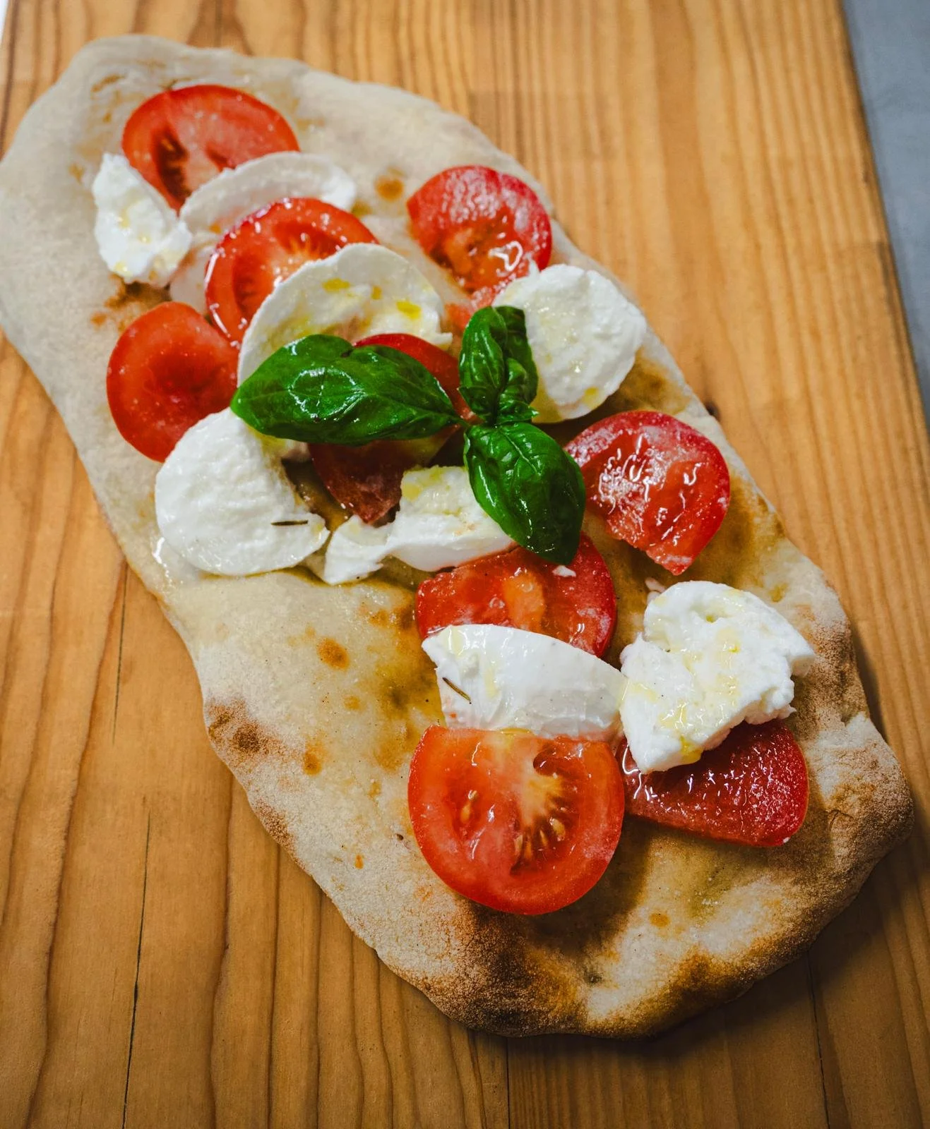 Focaccia con pomodori ciliegina, mozzarella, basilico e olio d'oliva