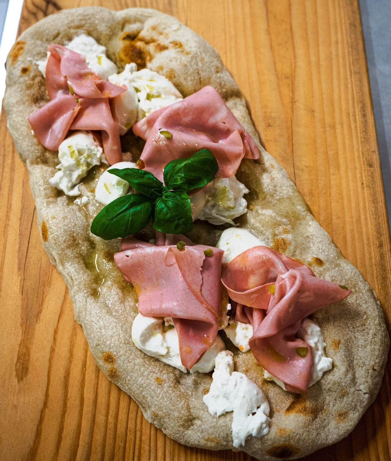Focaccia con prosciutto, mozzarella e basilico.