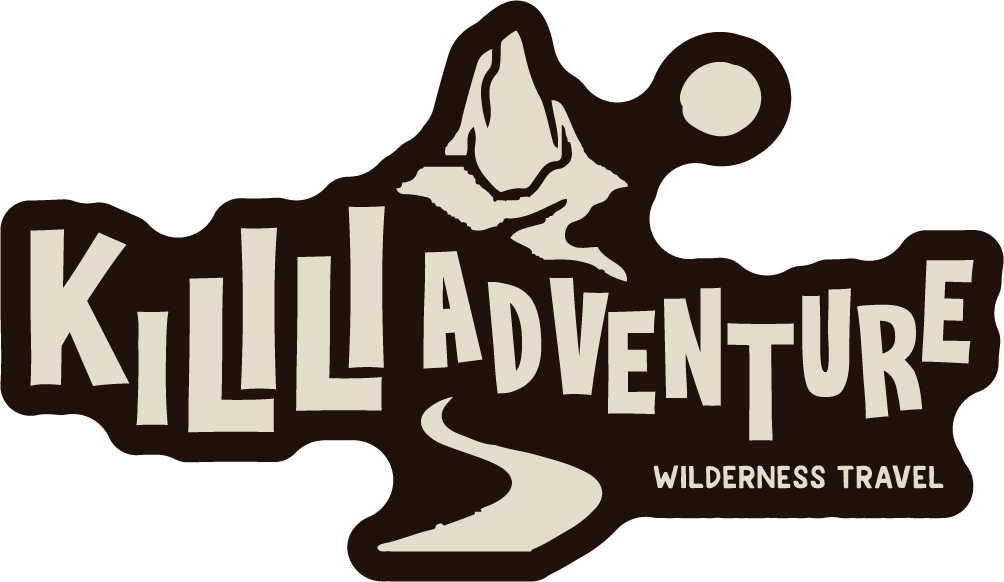 Logo de Killla Adventure, con una montaña, luna llena y camino de senderismo, acompañada del texto en inglés y español 'Travel Wilderness'
