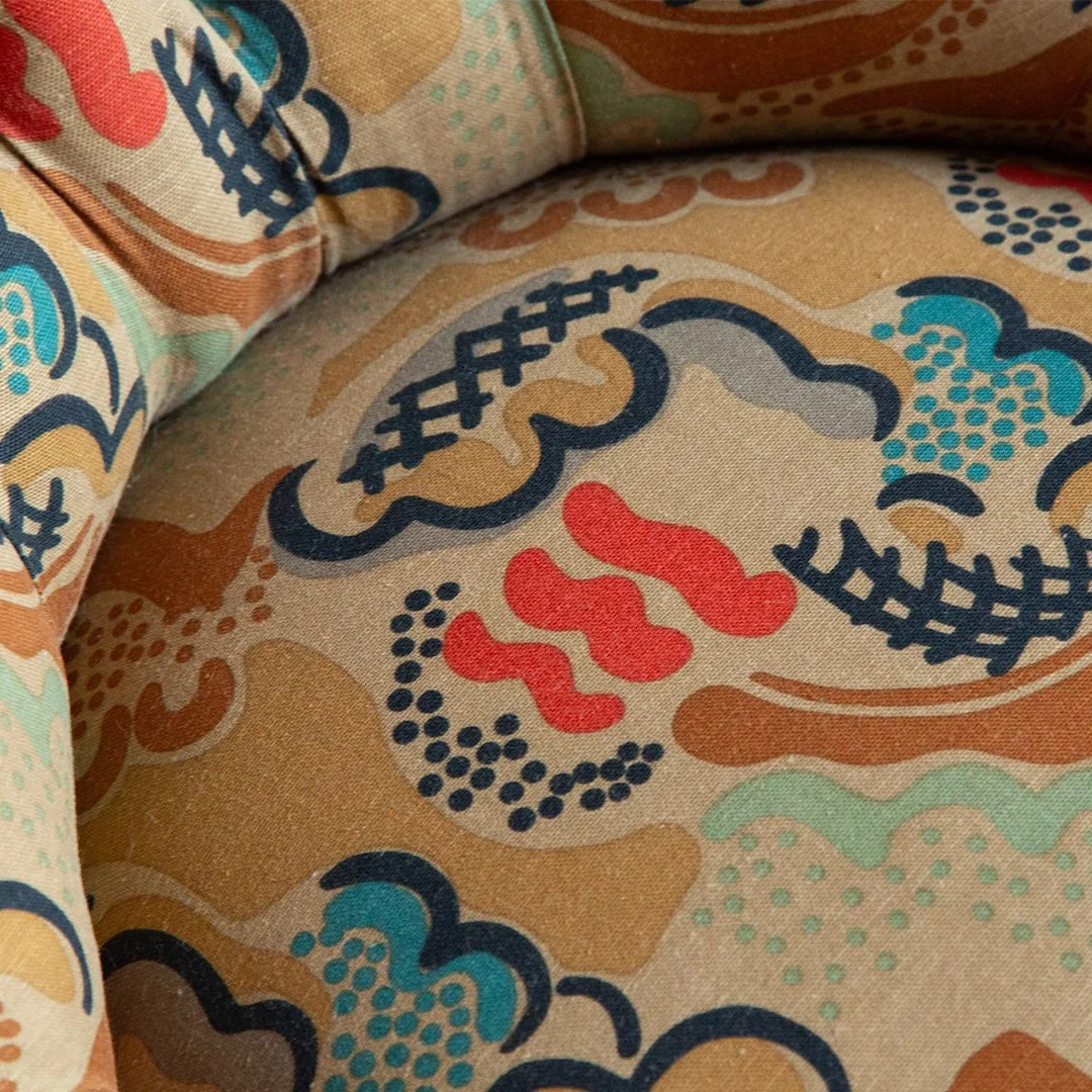 Close-up of fabric with colorful floral and abstract patterns in shades of blue, red, tan, and green.