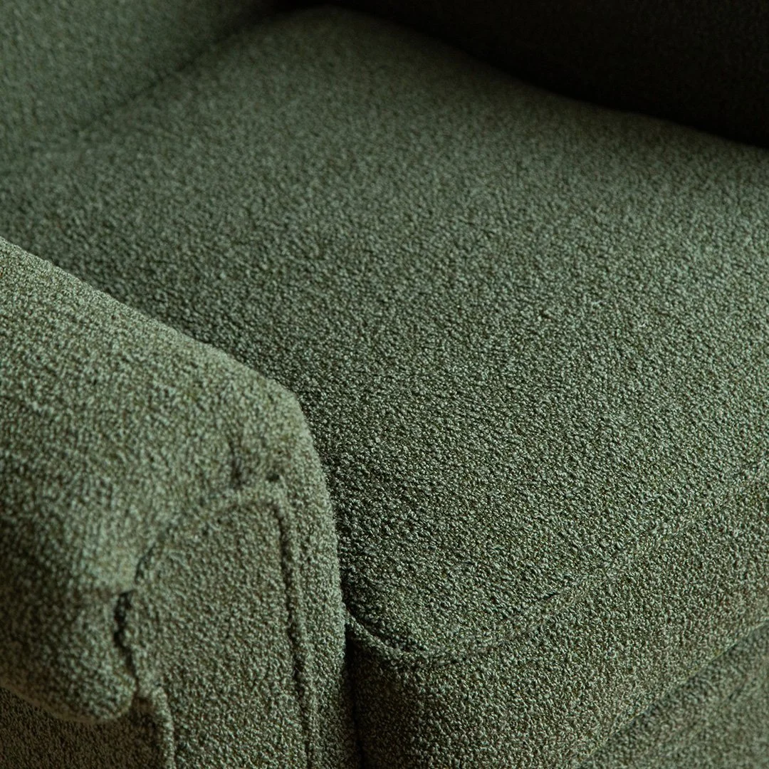 Close-up of green textured fabric on a sofa or chair.