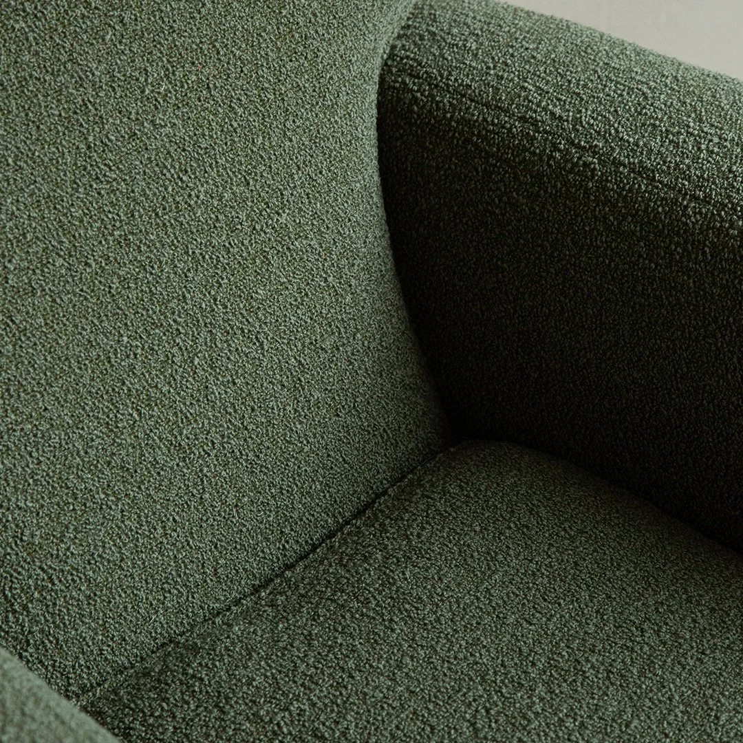 Close-up of a green textured fabric armchair armrest.