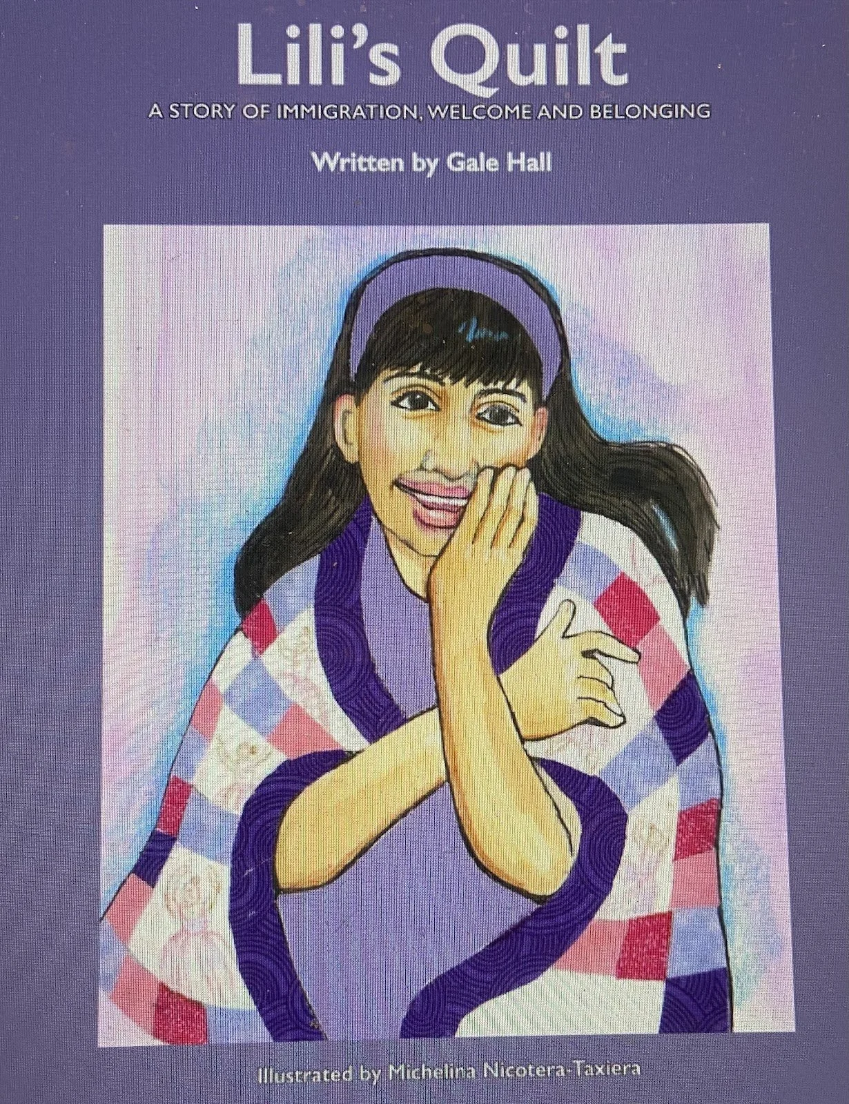 Cover of a book titled 'Lili's Quilt: A Story of Immigration, Welcome and Belonging' written by Gale Hall and illustrated by Michelina Nicotera-Taxiera. The cover features a colorful illustration of a young woman with dark hair, wearing a purple headband and a rainbow-patterned shawl, smiling and touching her face.