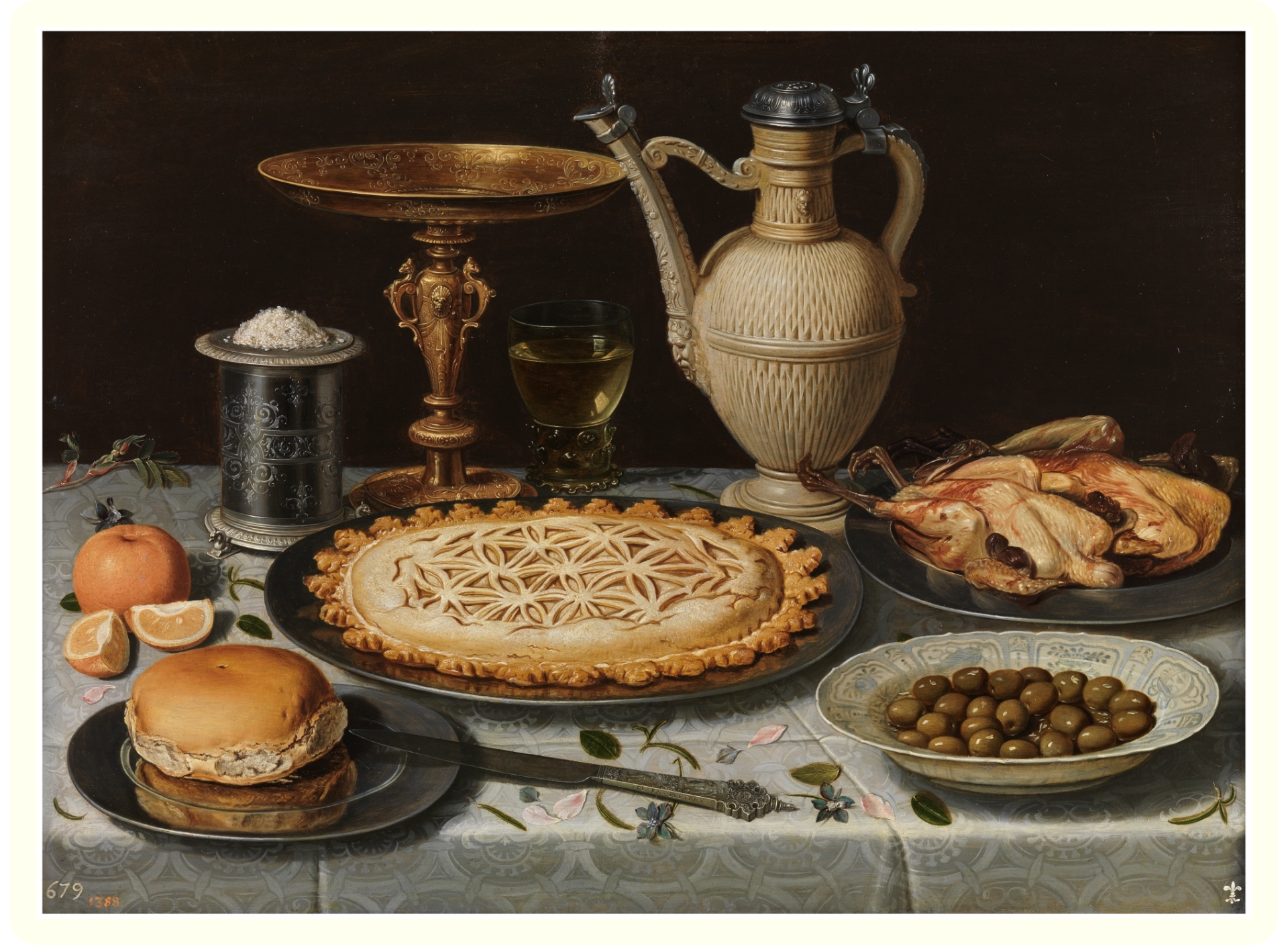 A still life painting of a table filled with food and decorative objects: a pie with an intricate lattice crust, roasted chickens, a bowl of green olives, a glass of white wine, an apple, sliced oranges, and a layered dessert. Decorative objects include a silver salt shaker with a leafy motif, a gold and black ornate platter, and a large, ancient-looking olive oil vessel with a spout.