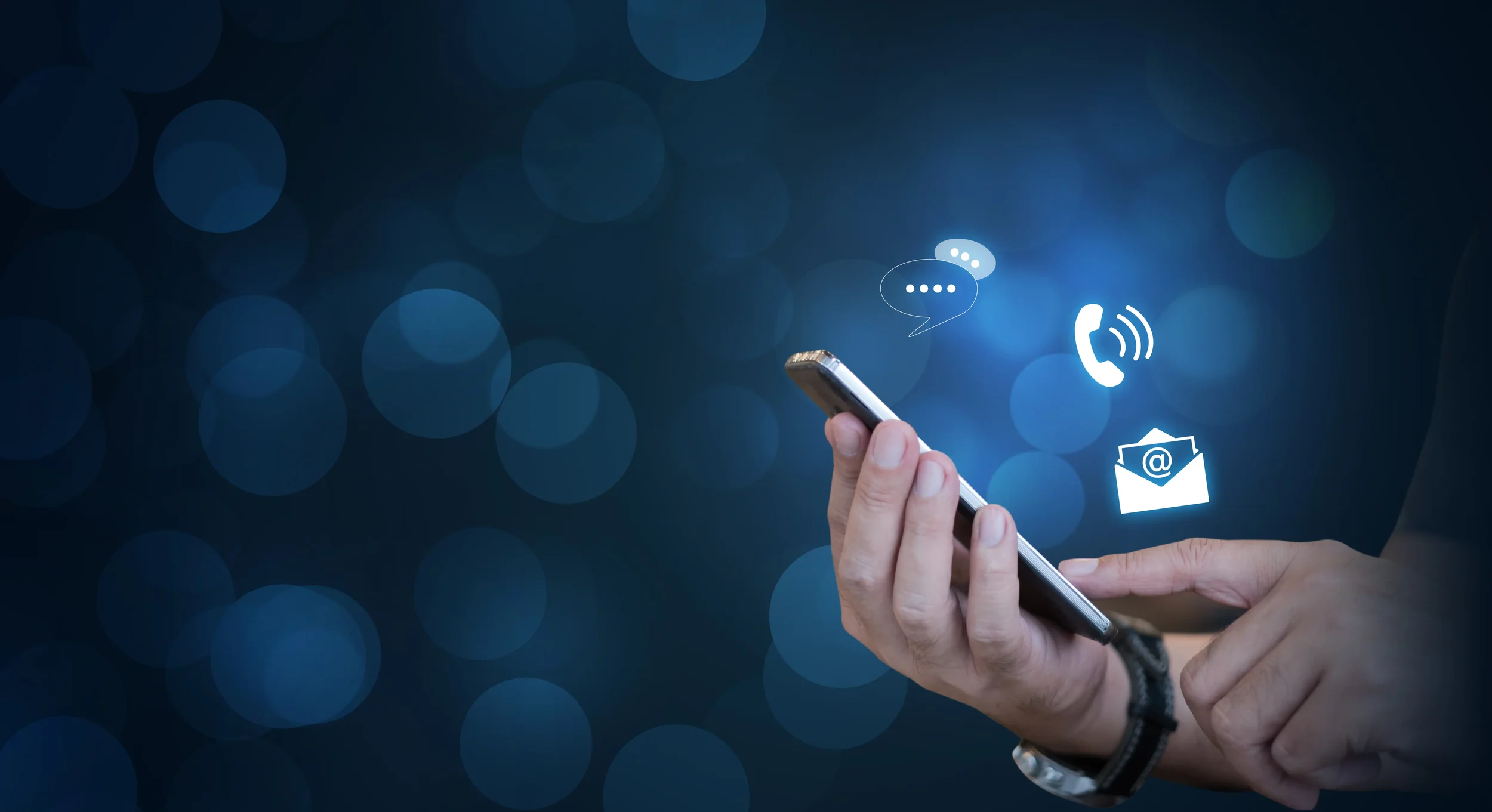 Hand holding smartphone with phone, email and message icons for security system enquiries